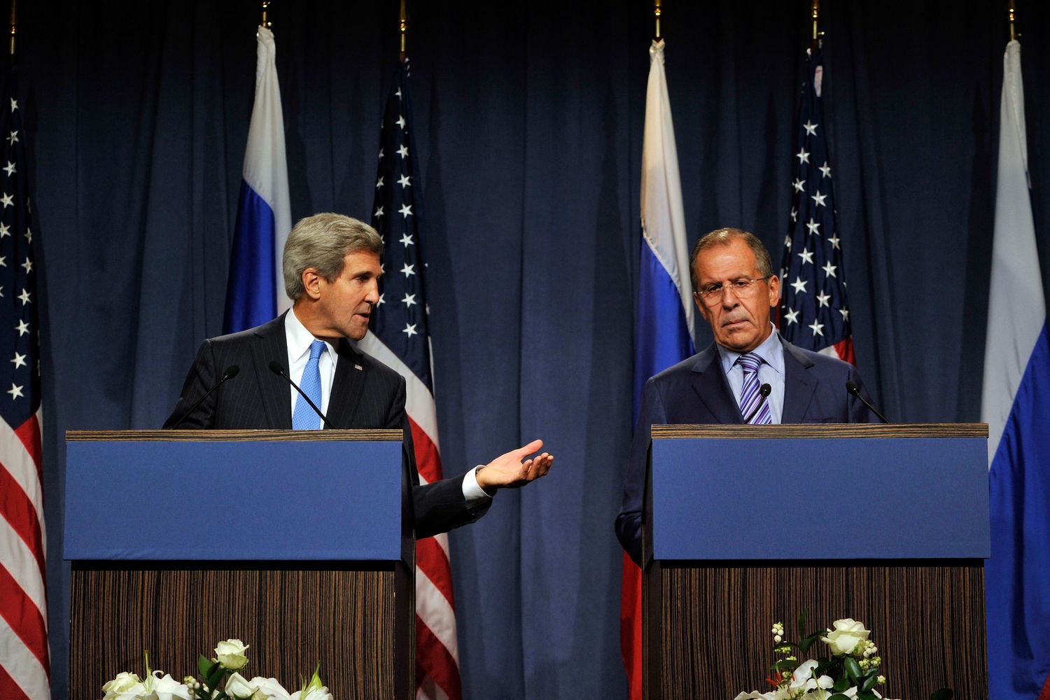 John Kerry and Sergei Lavrov speak at podiums during a diplomatic press conference.