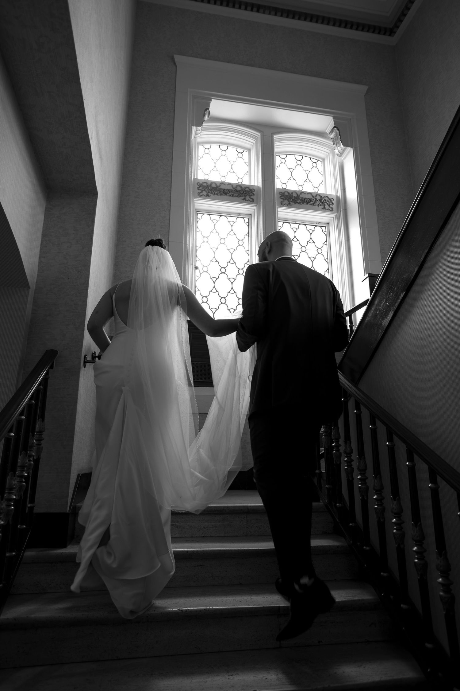 Dramatic black and white staircase scene with flowing wedding dress.
