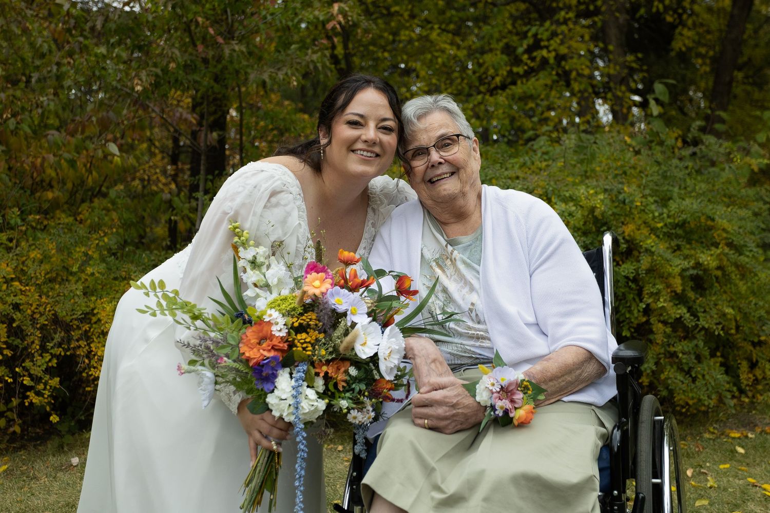 A couple shares a joyful moment with colorful floral bouquets in an outdoor setting.