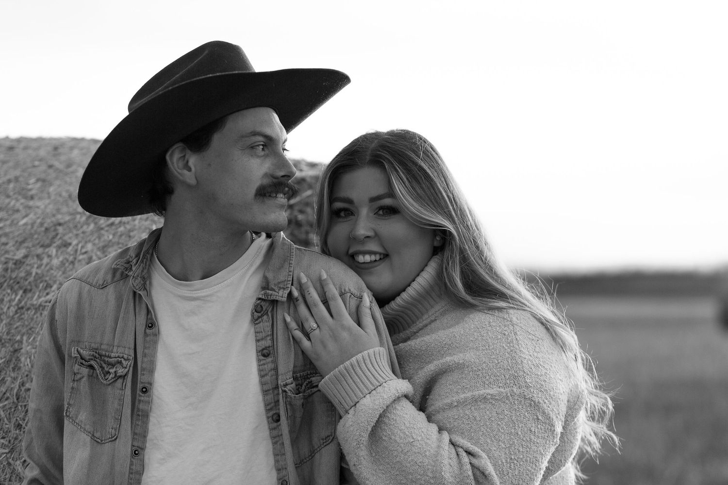 Romantic outdoor portrait with cowboy hat and sweater in golden sunlight.