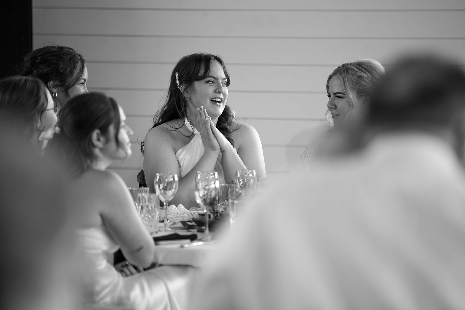 Black and white candid shot of guests at a reception table at the Barn at Wind's Edge in Saskatoon, Saskatchewan.
