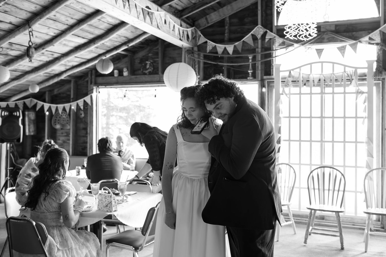 Wedding celebration inside rustic venue with hanging string lights and decorations at Grandma's House wedding venue in Langham, Saskatchewan