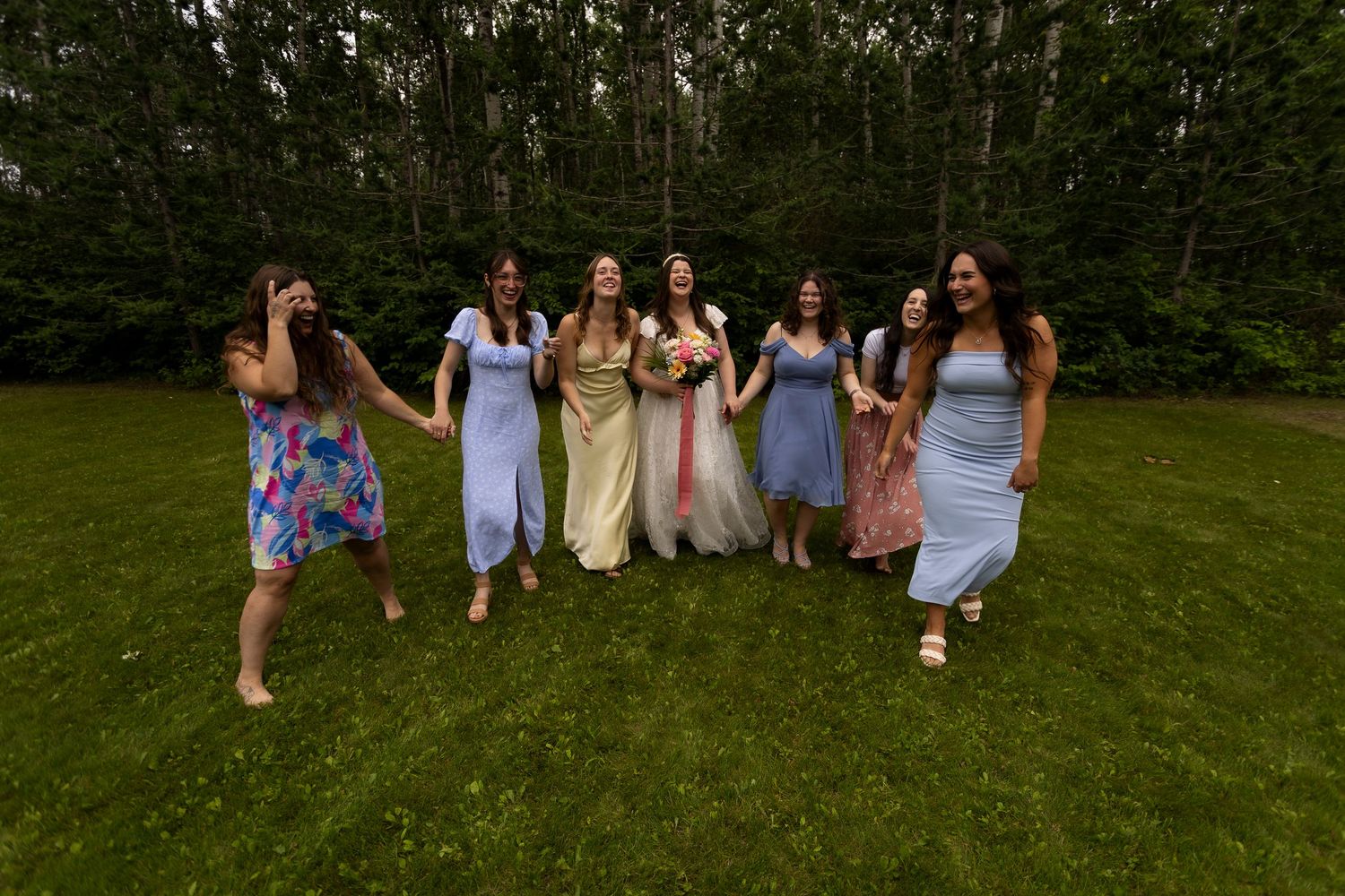 Group of people gathered on a grassy lawn during an outdoor celebration.