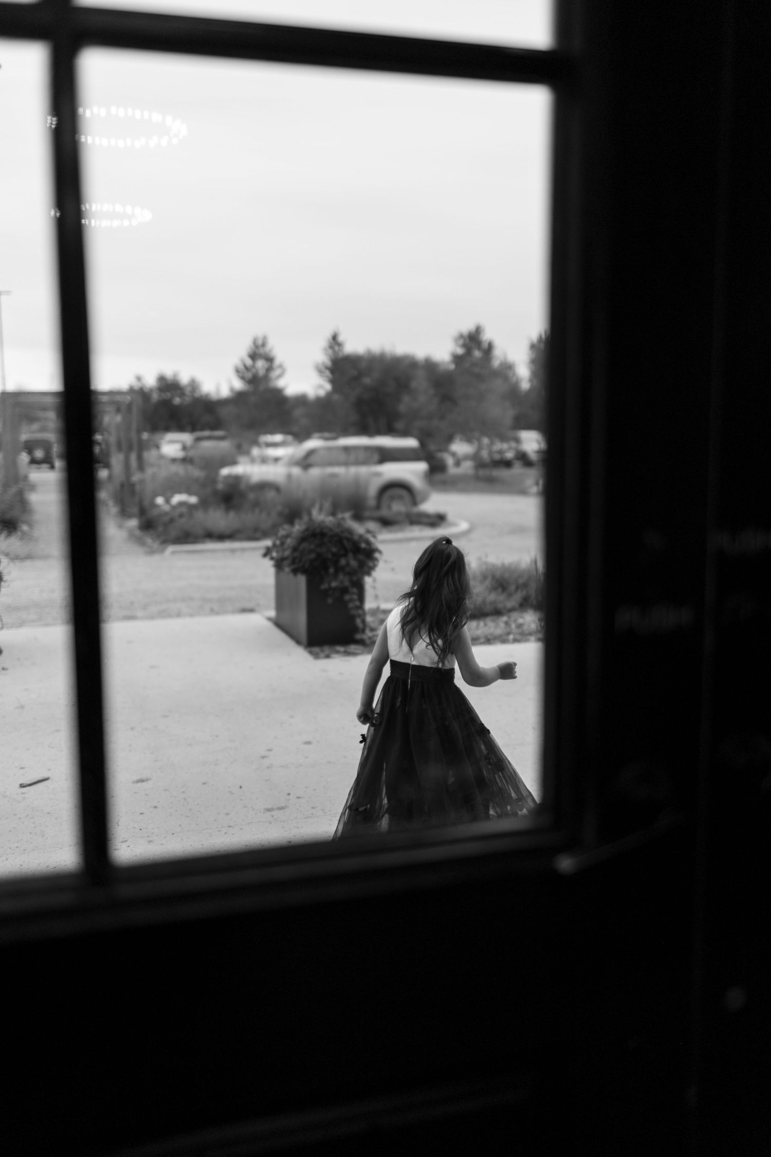 A silhouetted view through windows showing figures against a bright outdoor background.