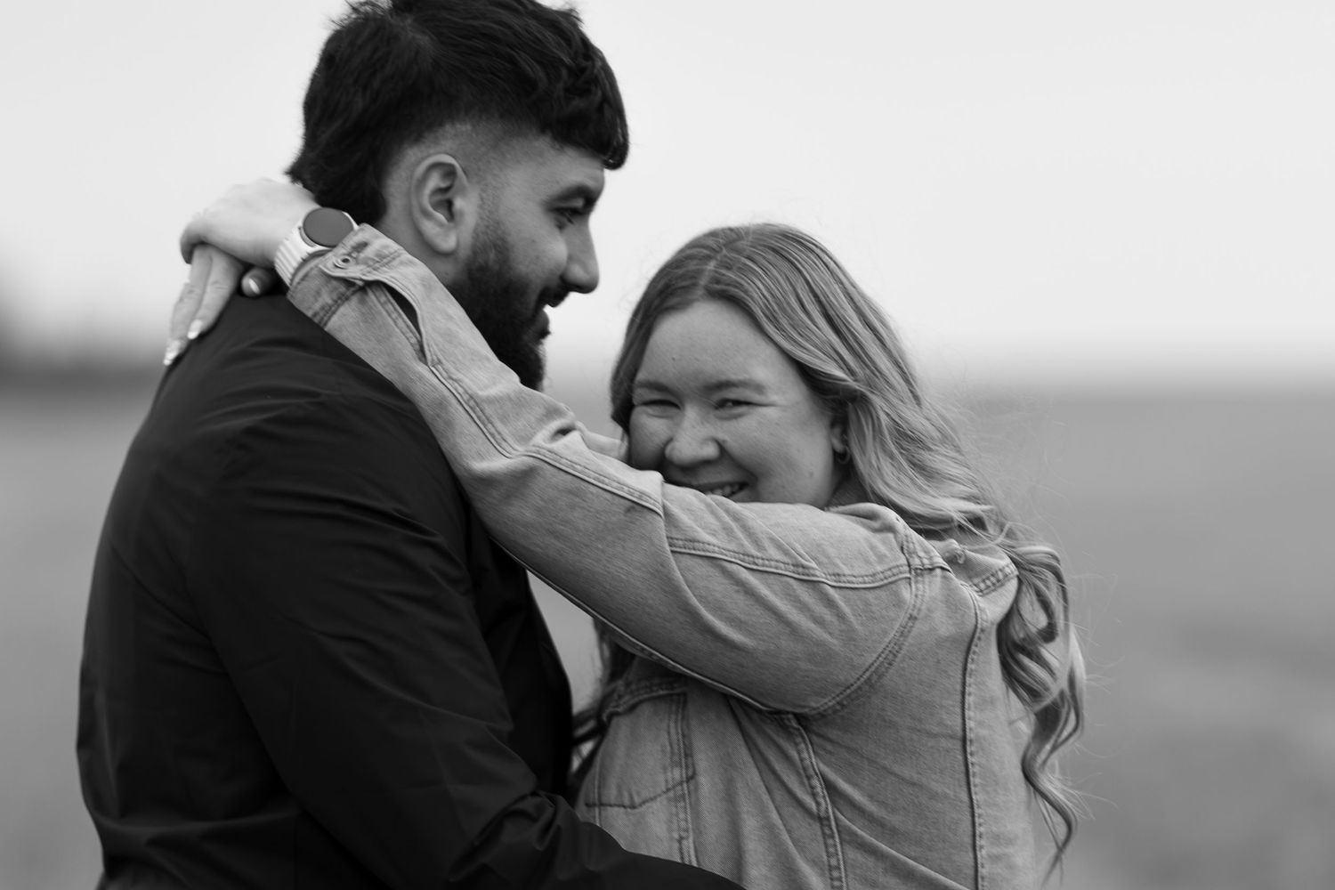 Candid black and white photos showing joyful moments between two people outdoors on a farm in Saskatchewan.