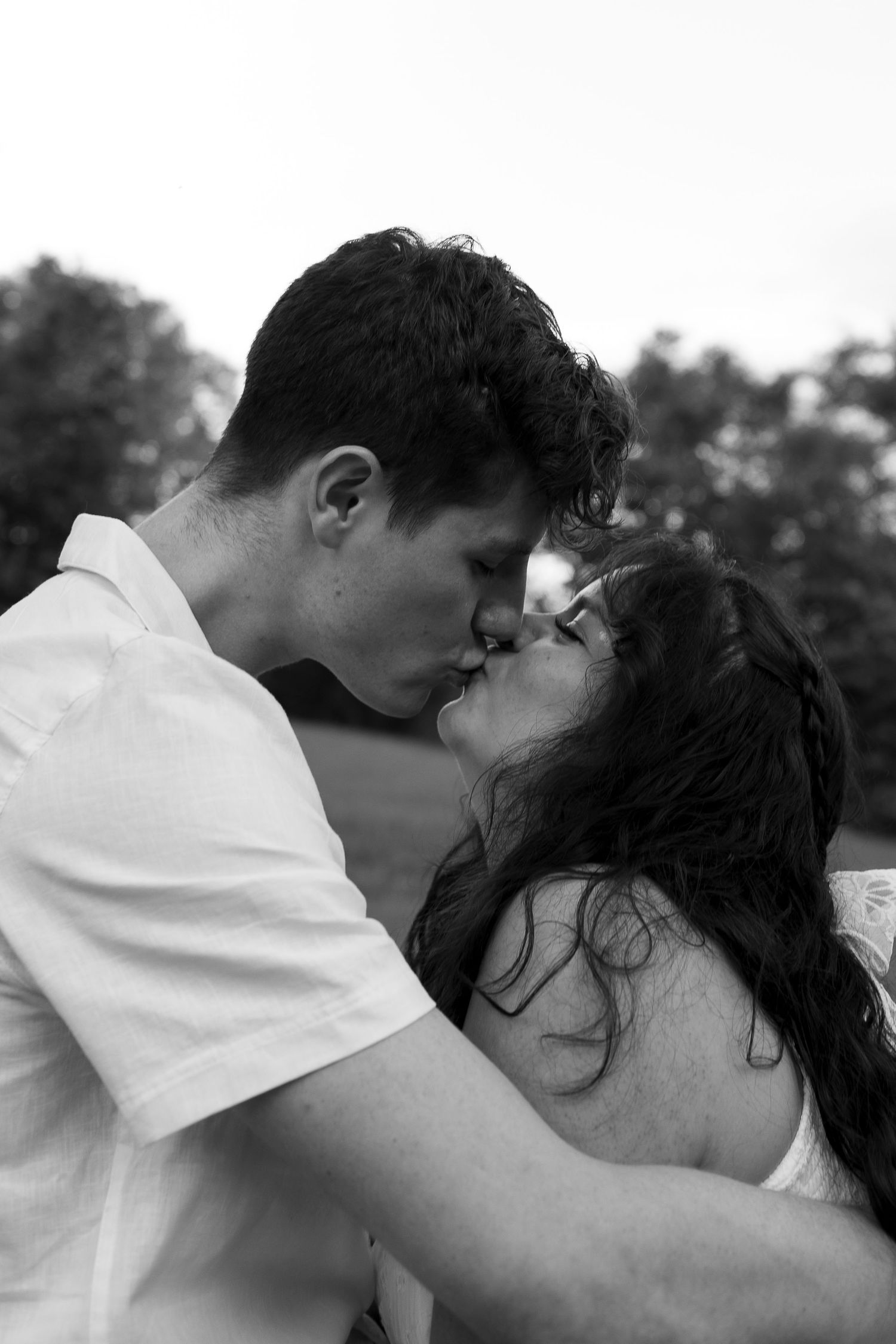 A tender moment captured between a couple in black and white photography.