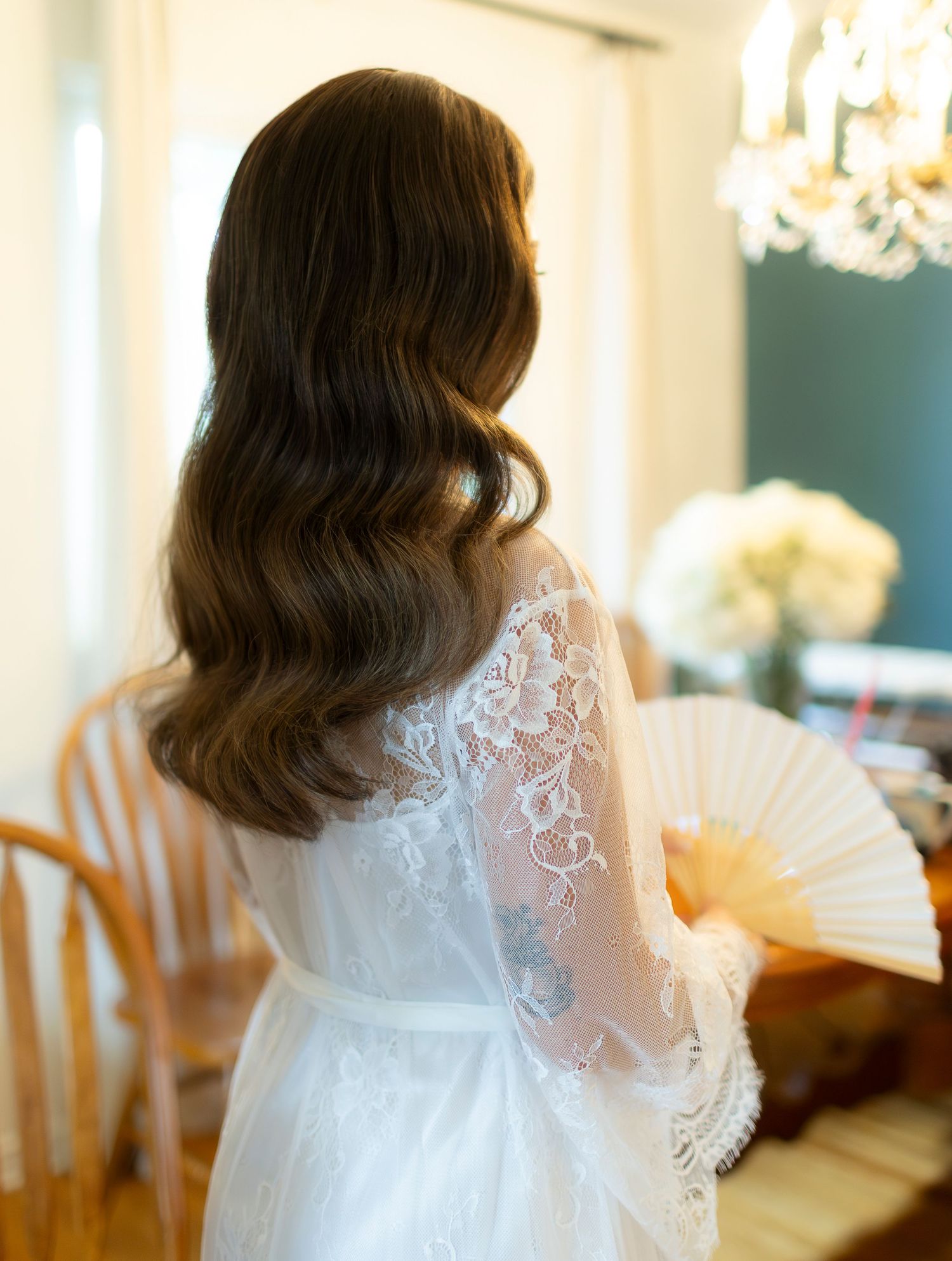 Delicate lace details on a white wedding dress shimmer in natural light.