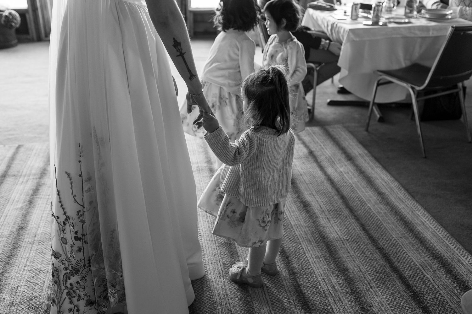 Wedding reception guests mingle and dance in an indoor venue.