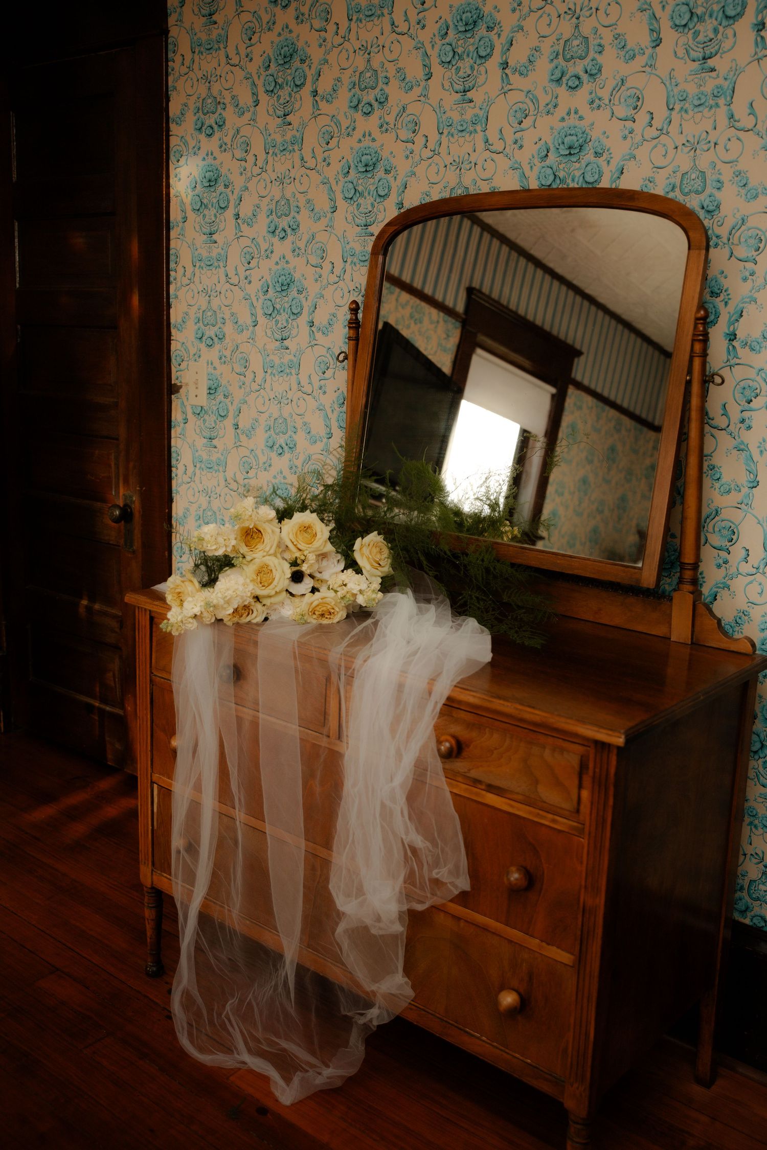 A vintage wooden dresser with mirror displays a wedding veil and floral decorations at the Lawrence House in Saskatoon, Saskatchewan.