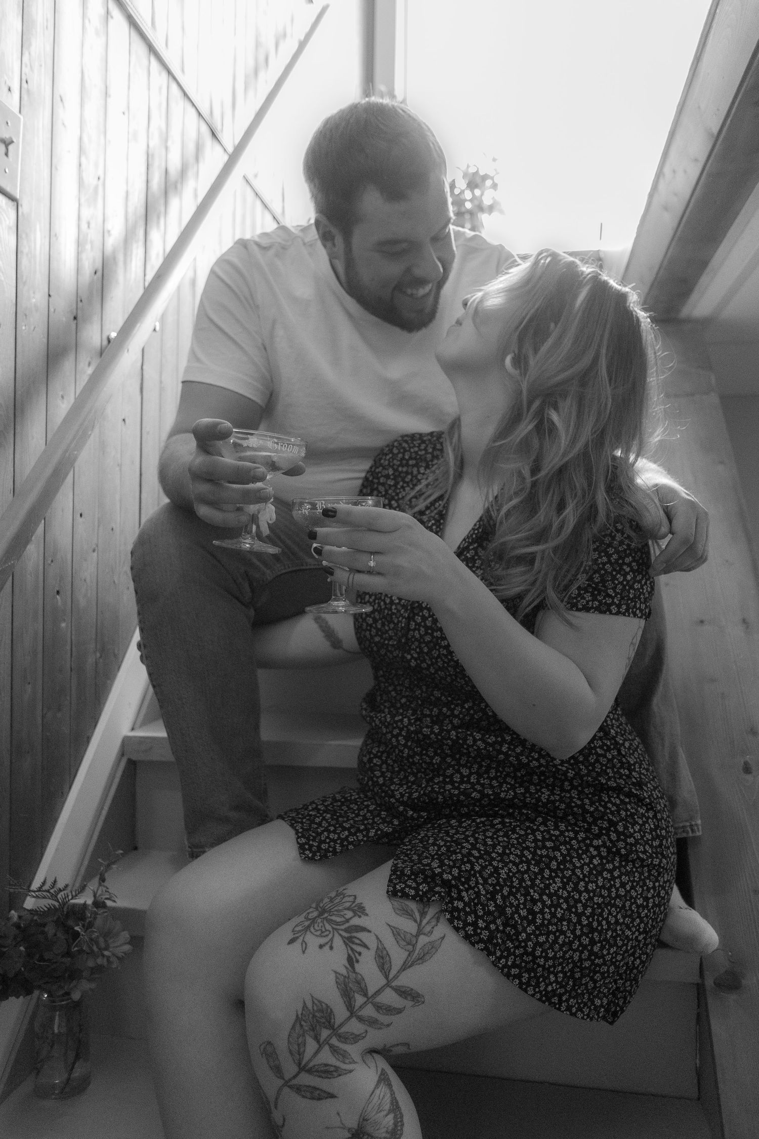 A tender black and white moment shared between two people sitting on outdoor steps.