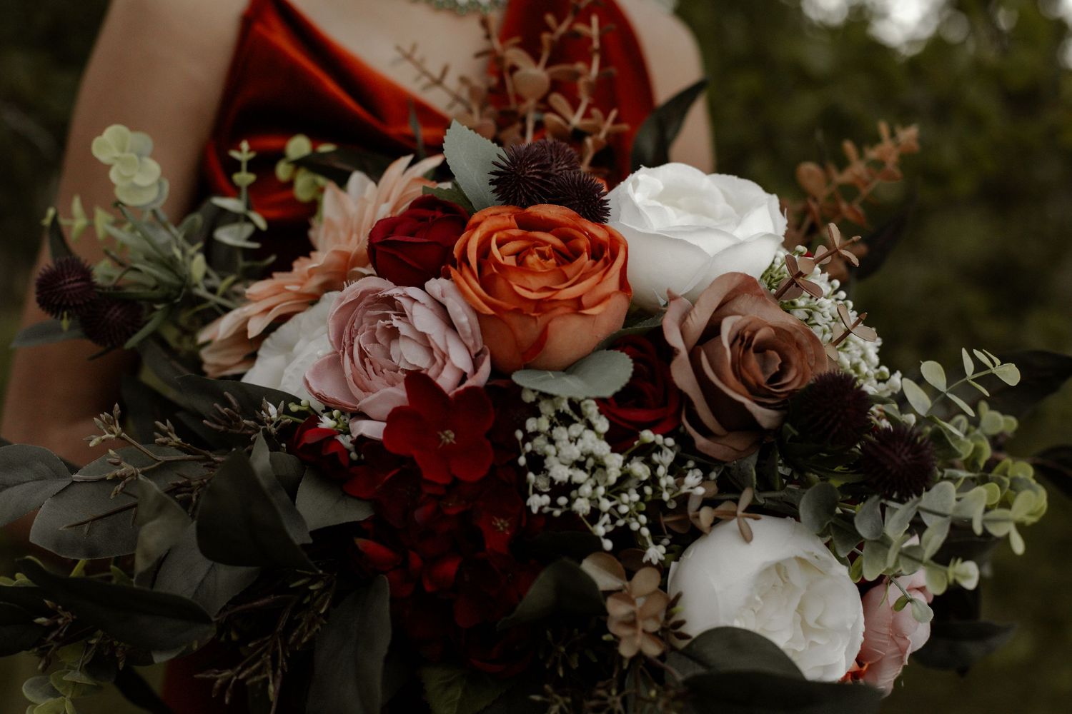 Romantic table setting with pink and red roses mixed with delicate greenery.