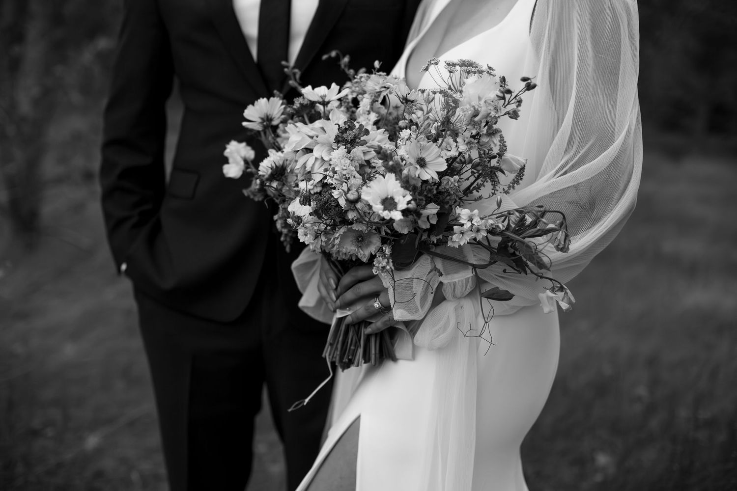 Black and white wedding photo with elegant floral bouquet arrangement.