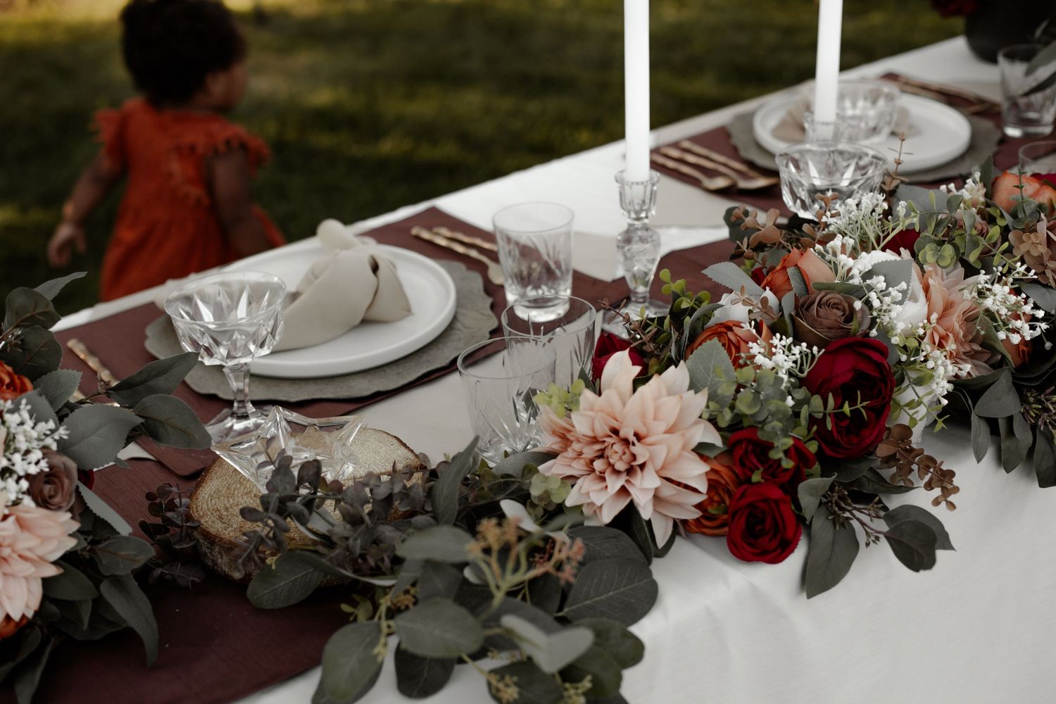 Wedding reception table with elegant floral centerpieces and formal place settings.
