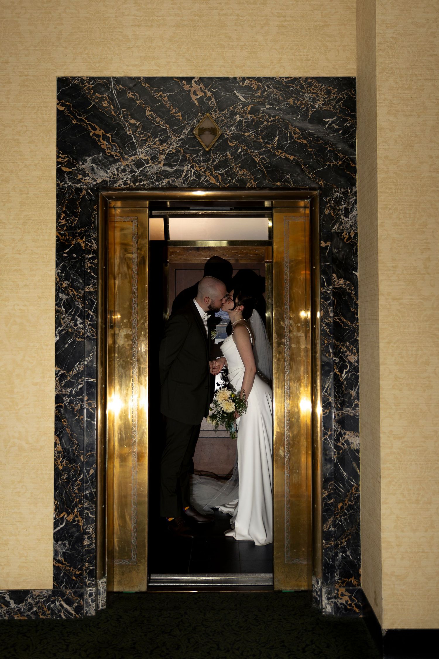Elegant marble hallway with gold accents creates dramatic wedding venue atmosphere.