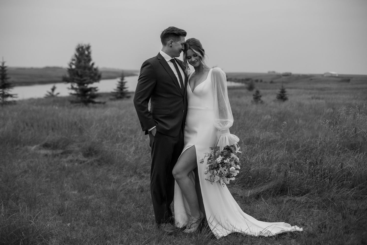 Romantic black and white portrait of newlyweds in an open field.