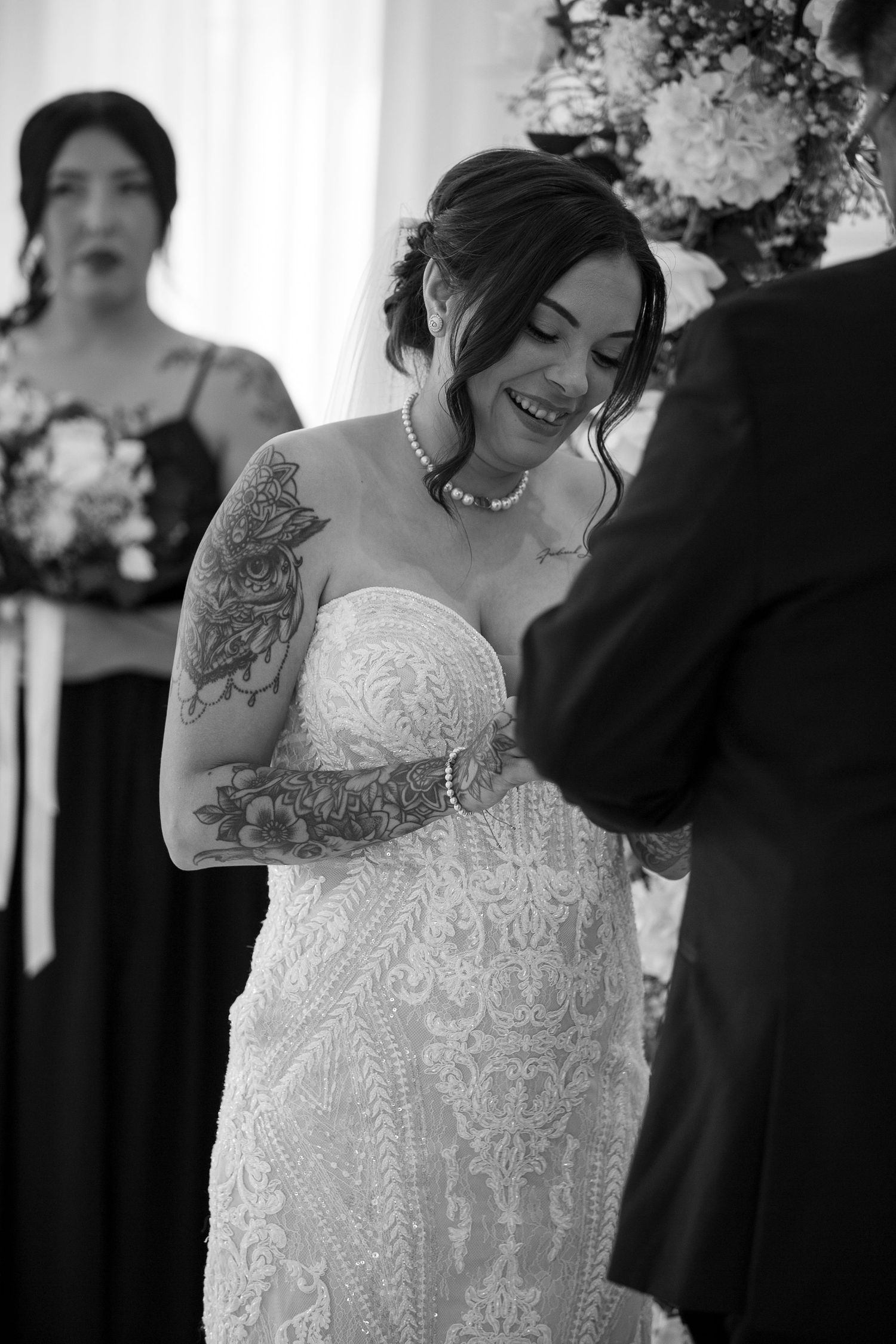 A beautiful lace wedding dress with intricate details and patterns captured in black and white.