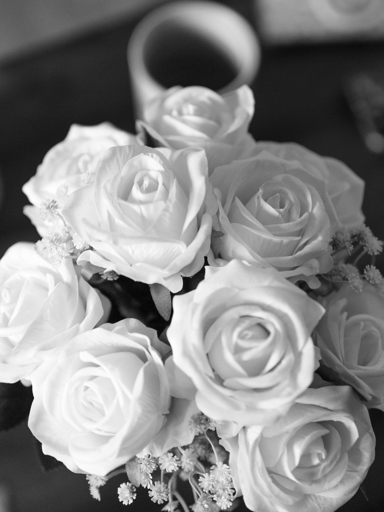 Beautiful white roses arranged in a delicate bouquet with soft focus black and white photography.