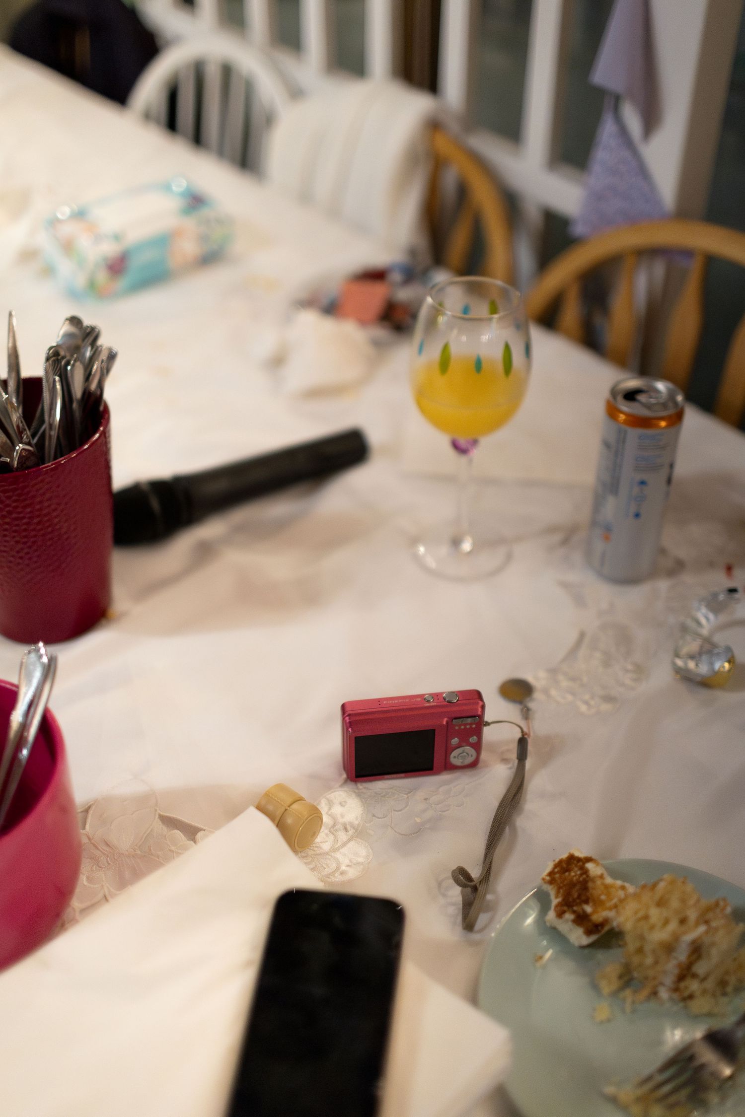 Elegant table setting with white linens and burgundy accents at a formal event.
