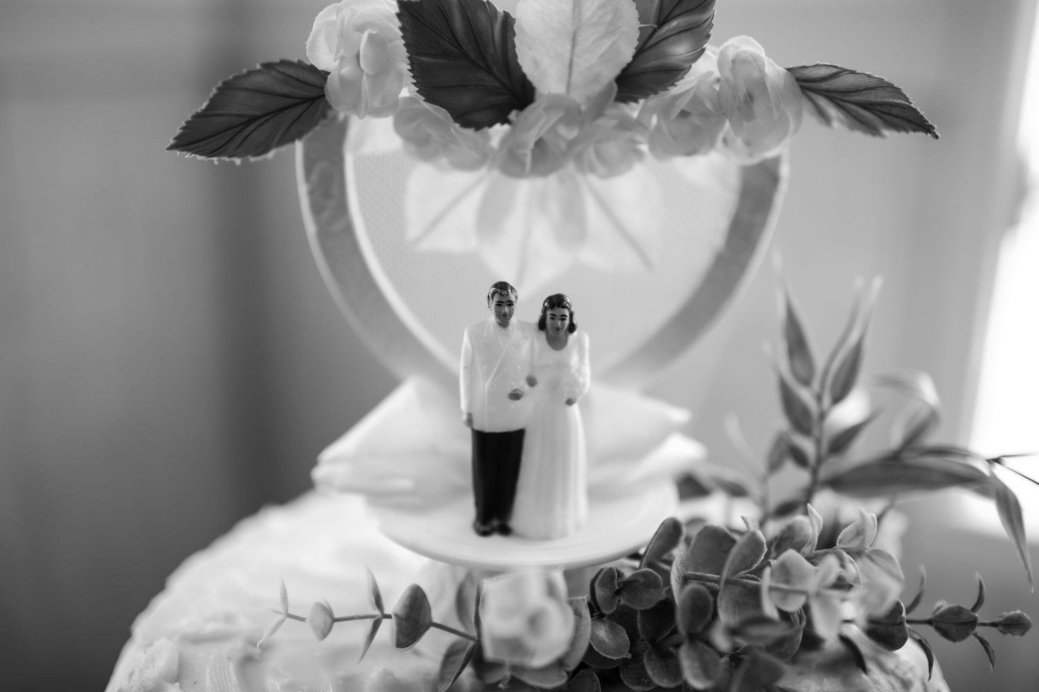 Black and white photo of elegant floral wedding decorations arranged on tables.