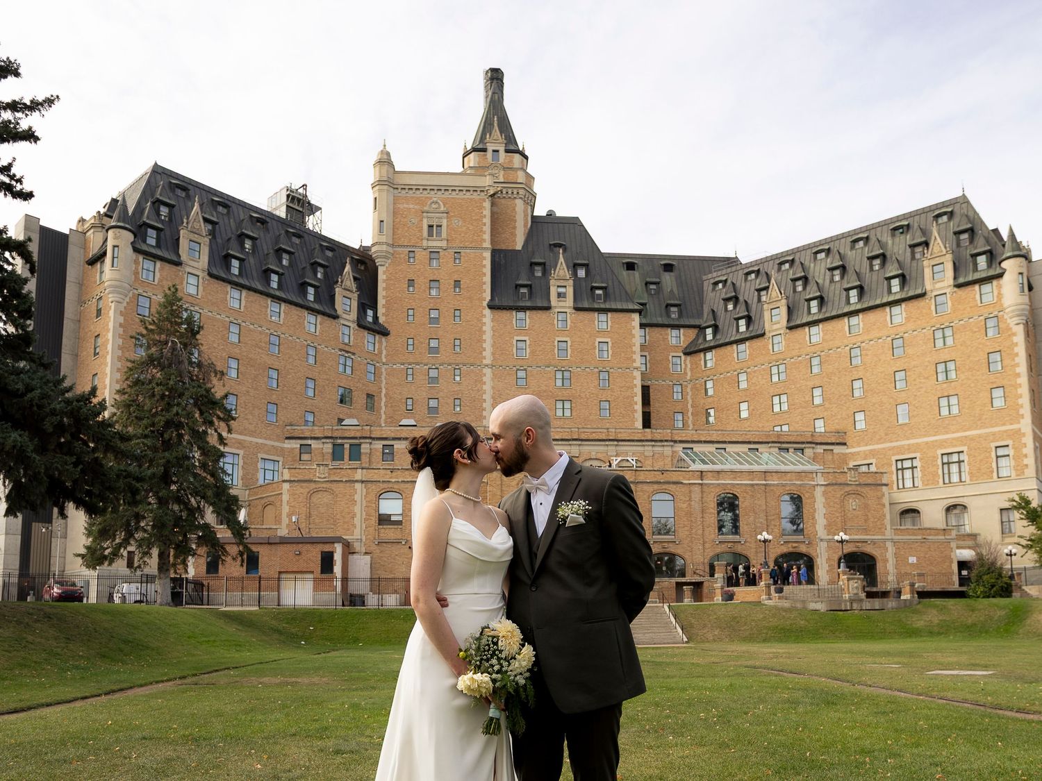 Bride and groom kissing in front of the historic Bessborough Hotel in Saskatoon on their wedding day.