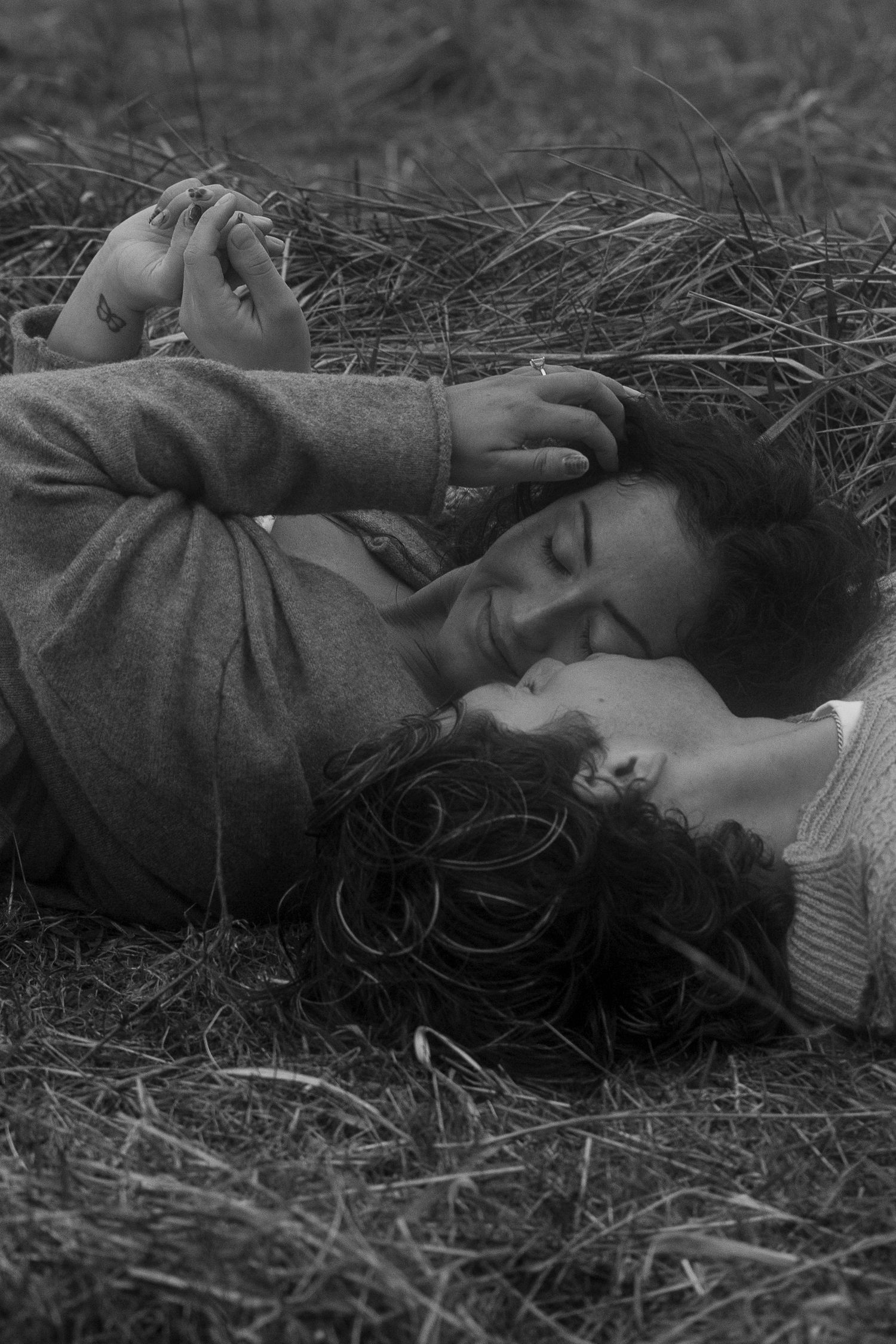 A black and white sequence of someone resting peacefully in tall grass.