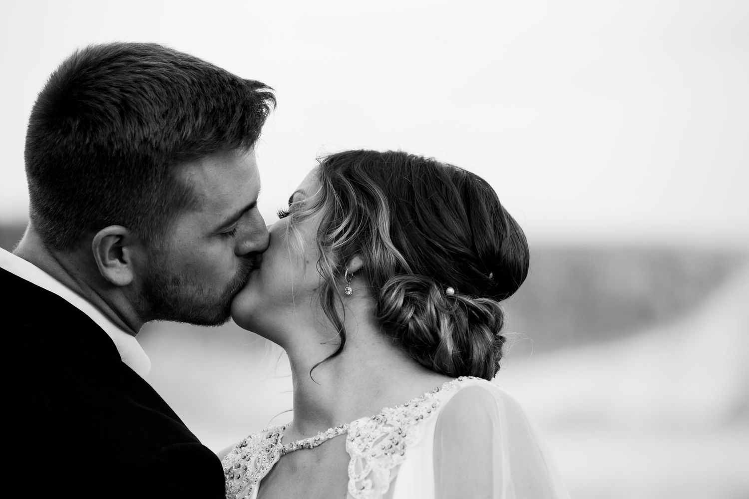Romantic wedding moment captured in soft black and white tones.