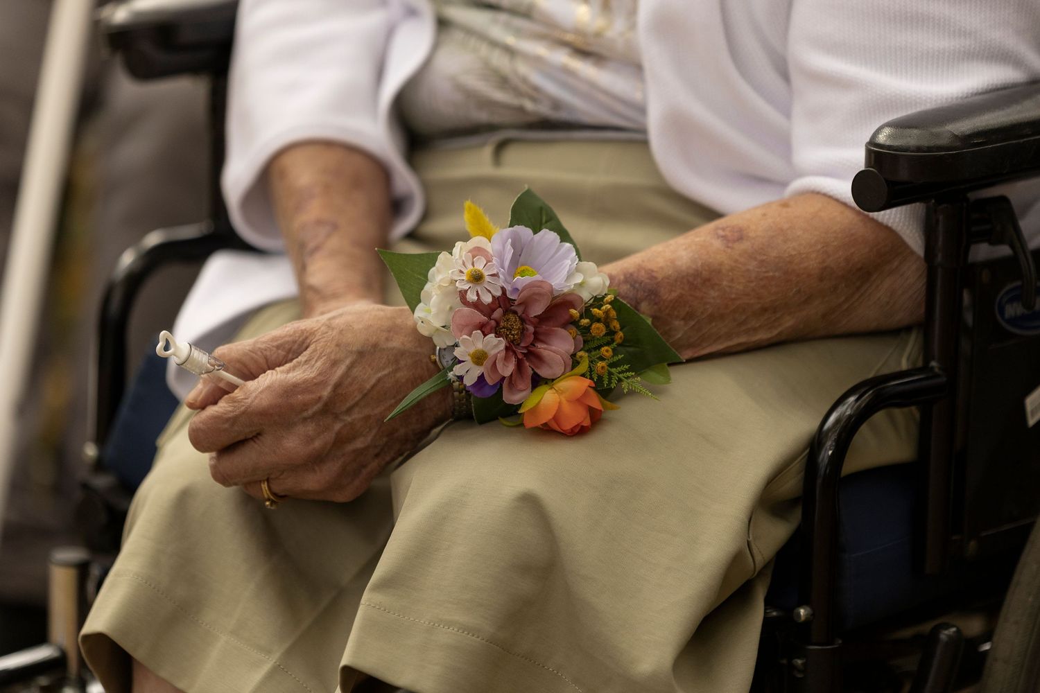 Close-up of hands holding vibrant floral bouquets during a wedding ceremony.