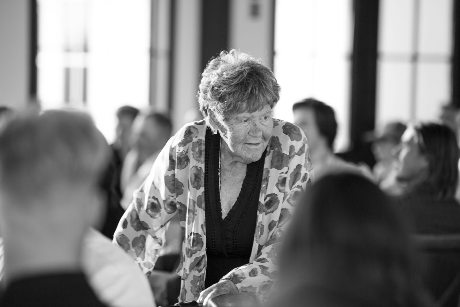 Black and white photo of people gathered at an indoor event at the Barn at Wind's Edge in Saskatoon, Saskatchewan.