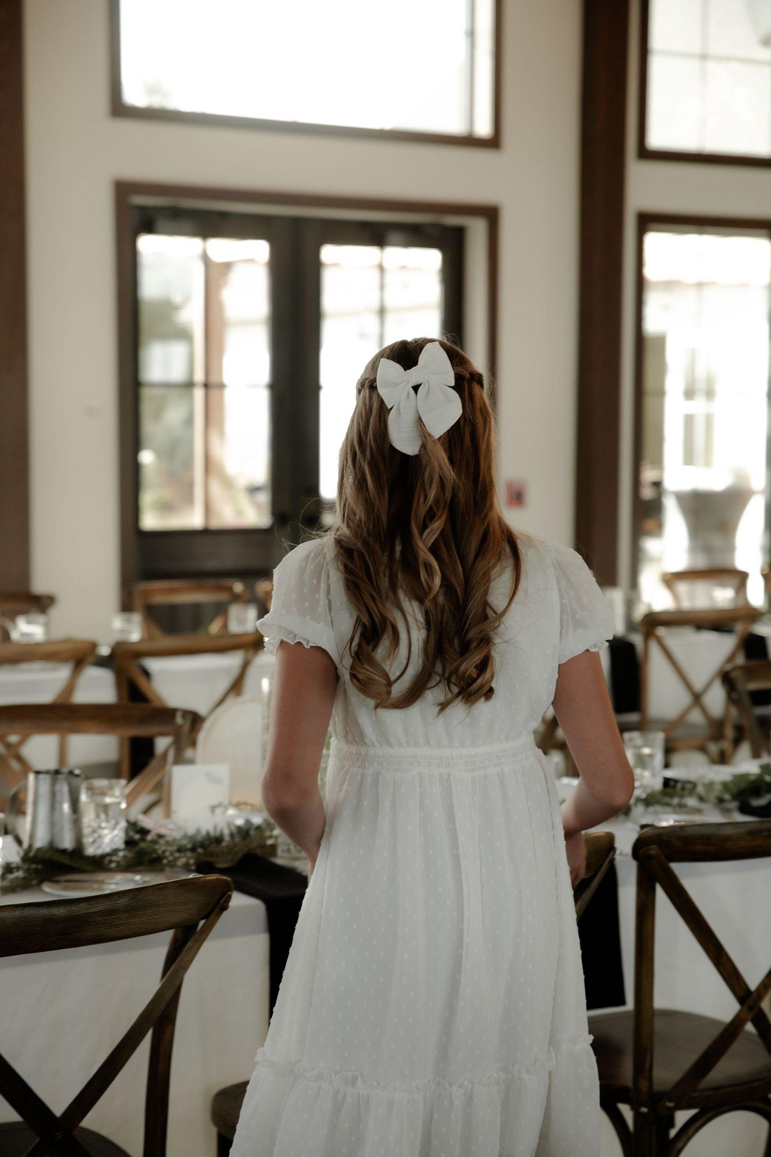 White dress seen from behind in a bright indoor reception venue at the Barn at Wind's Edge in Saskatoon, Saskatchewan.