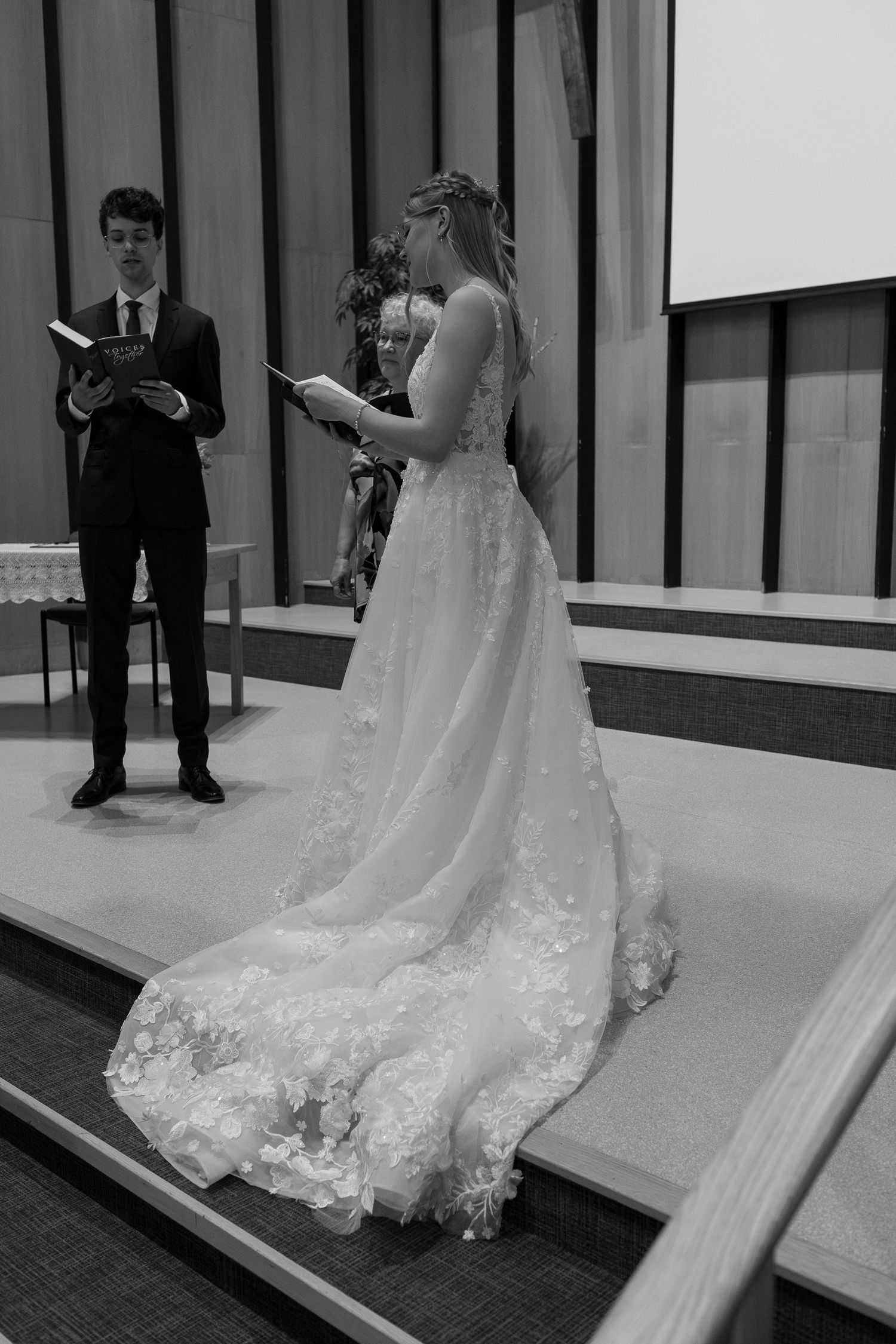 A wedding ceremony taking place on a modern stage with dramatic lighting and decor.