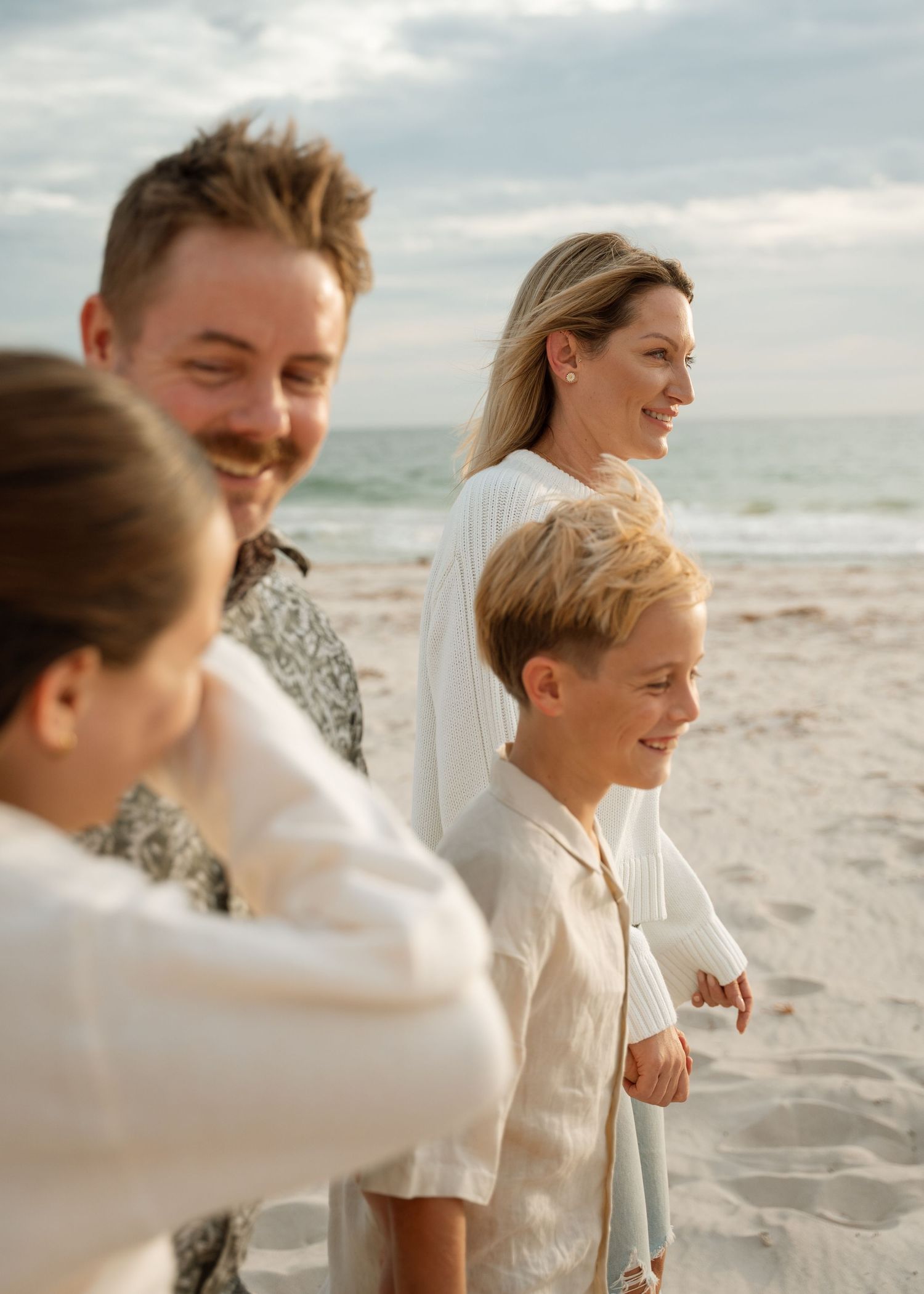A family photography session at the beach at sunset with their 2 children.