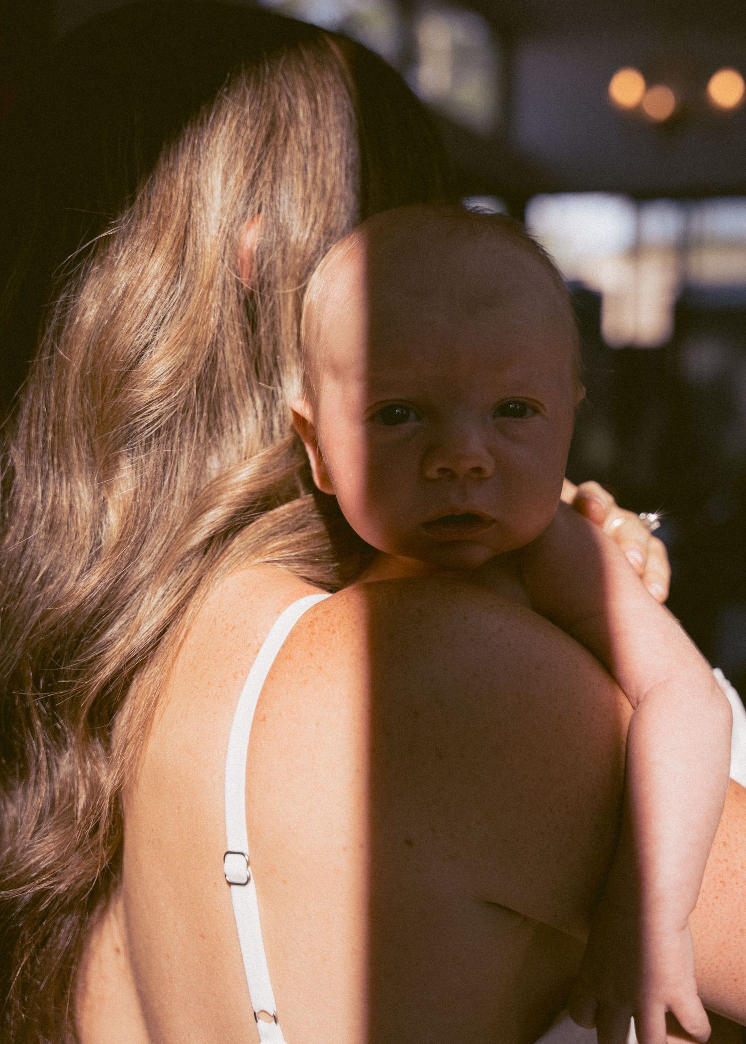 A mother and her newborn baby at a newborn photography session at home.