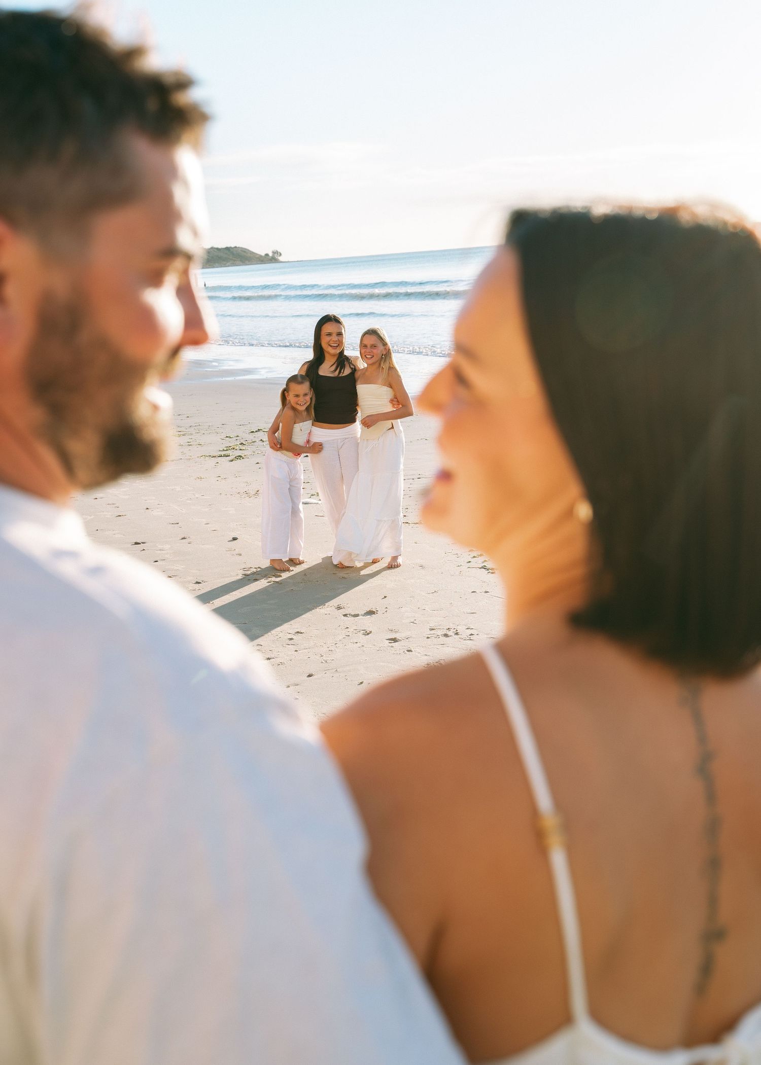 A family photography session at the beach at sunset with their 3 teenage daughters.
