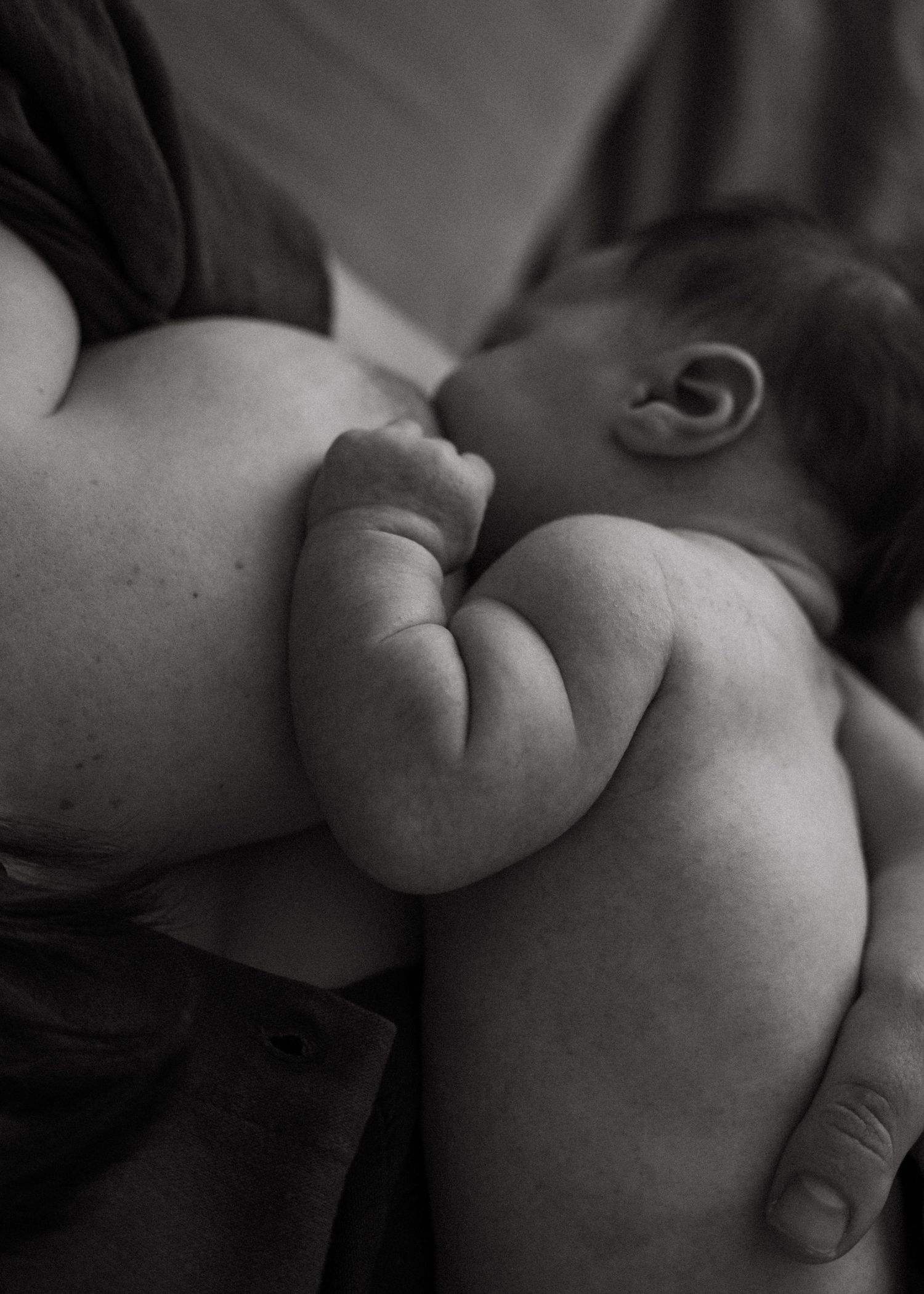 A mother and her newborn baby at a newborn photography session at home.