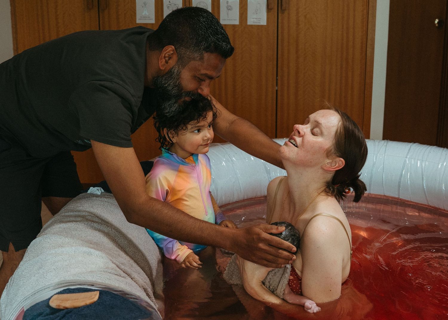 A new mother feeling relief after she has given birth to her second child. Birth photography in Adelaide at a home birth.