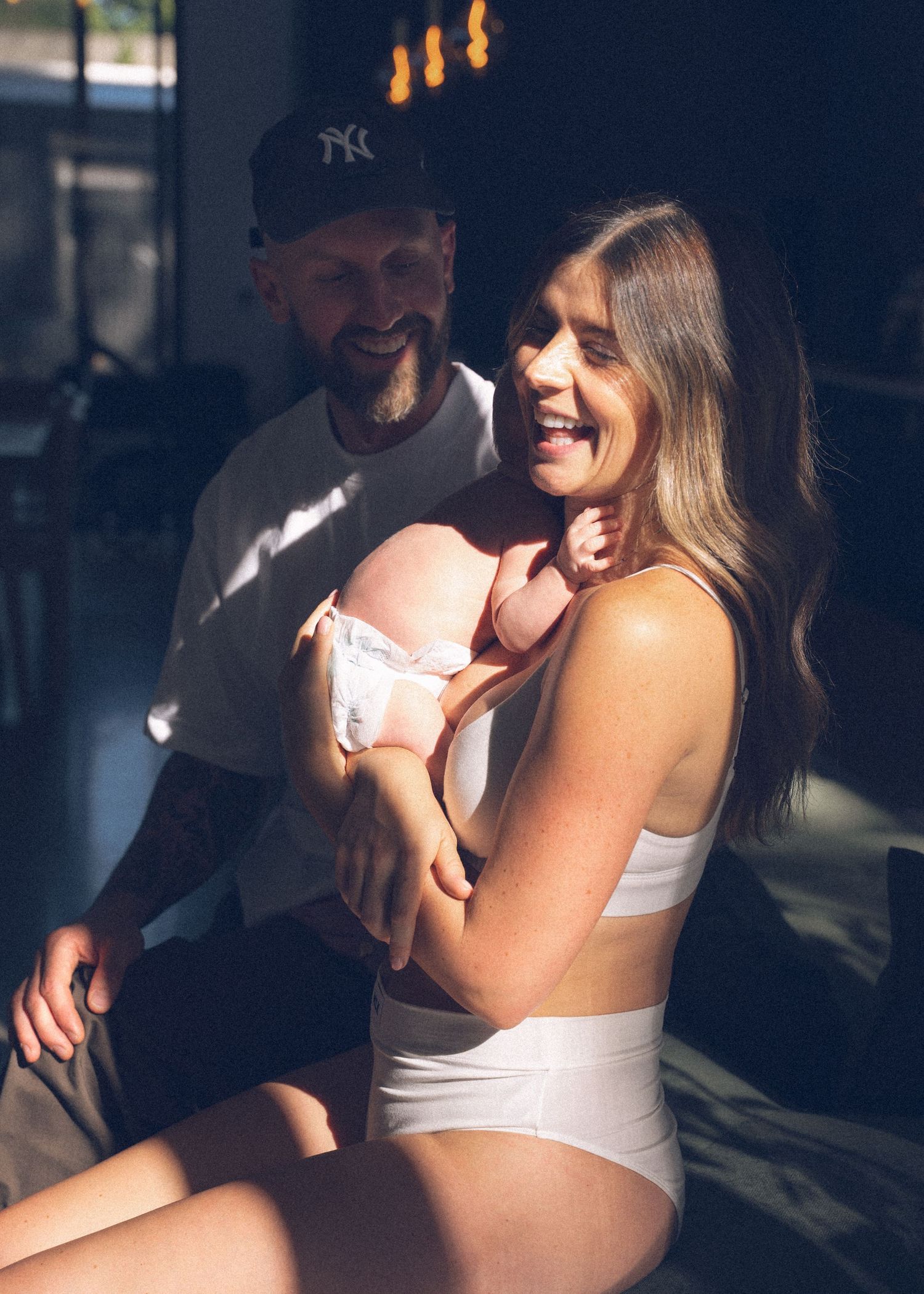 A mother and her newborn baby at a newborn photography session at home.