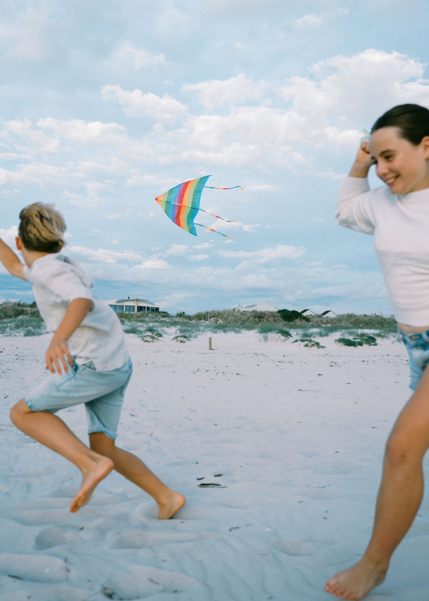 A family photography session at the beach at sunset with their 2 children.