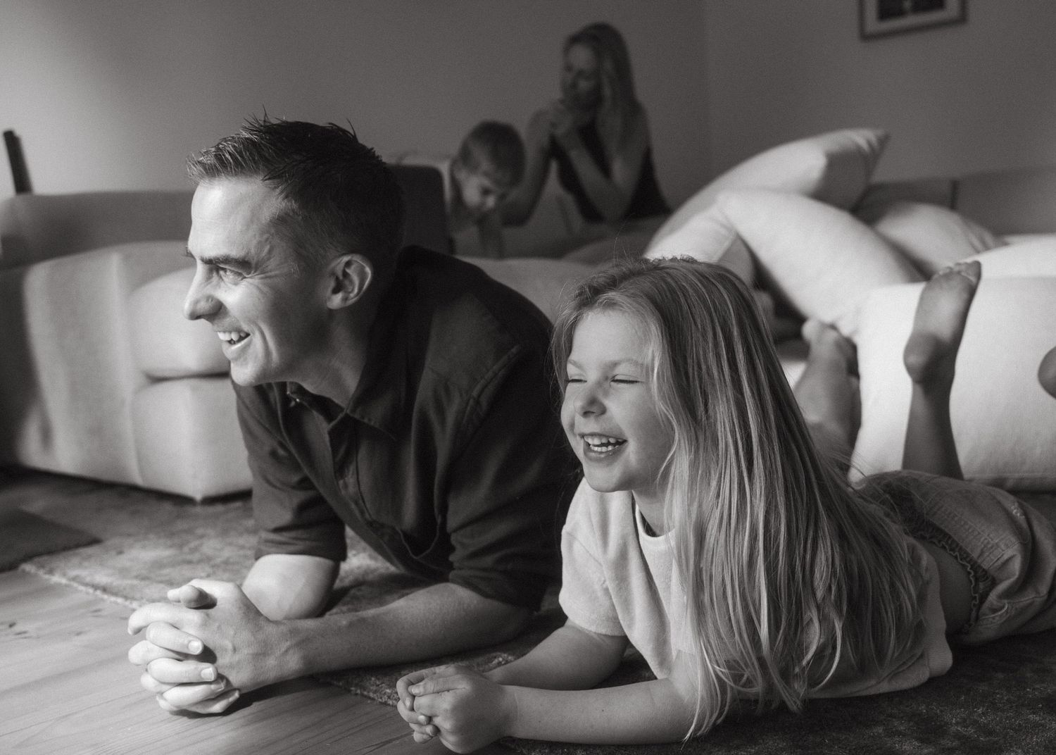 A father and his daughter playing and laughing at a family photoshoot at their family home.