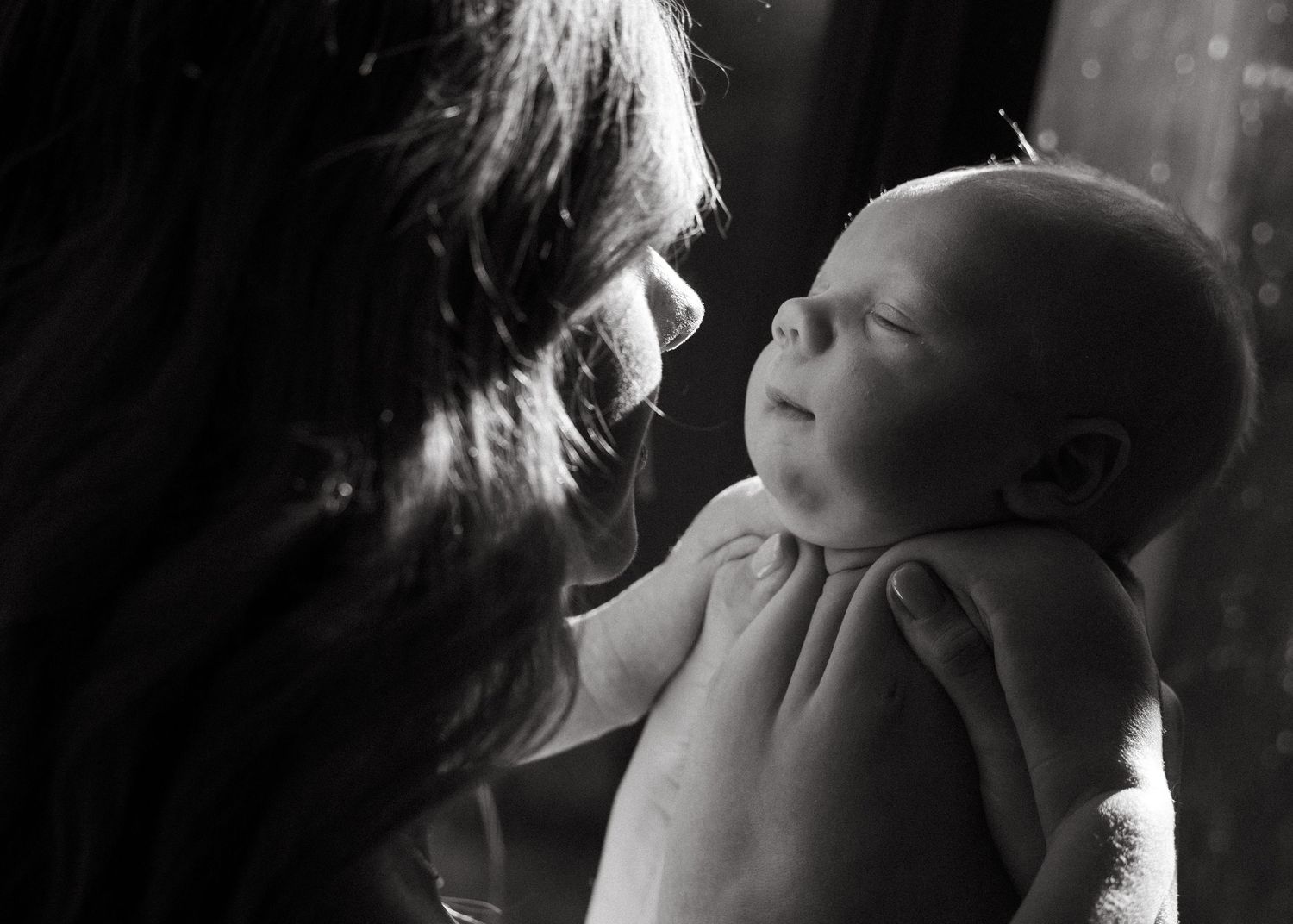 A mother and her newborn baby at a newborn photography session at home.