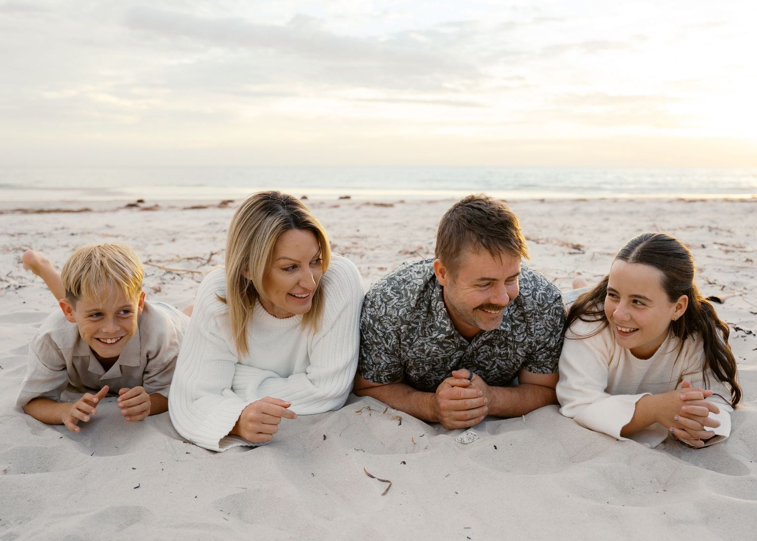 A family photography session at the beach at sunset with their 2 children.