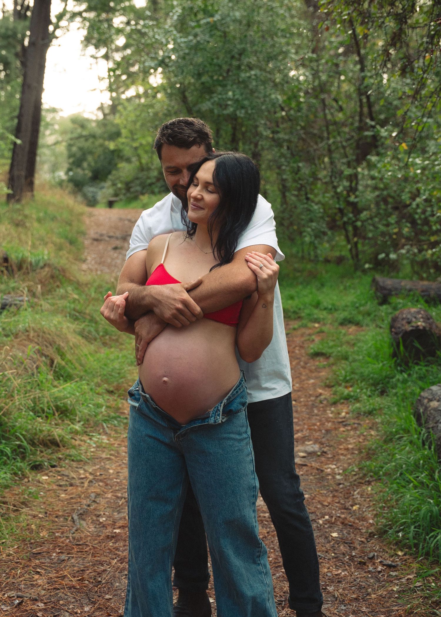 An Adelaide couple at a maternity photoshoot in the forest at golden hour.