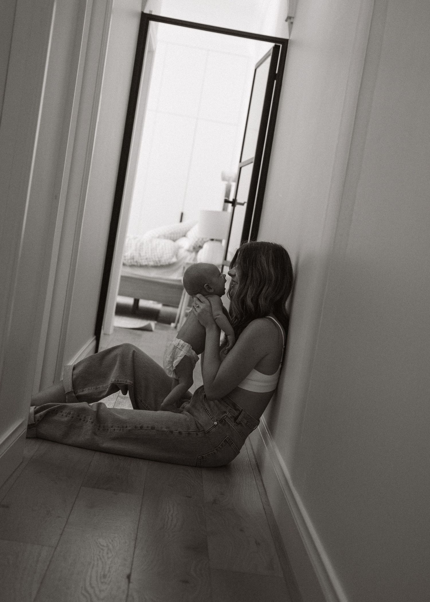 A mother and her newborn baby at a newborn photography session at home.