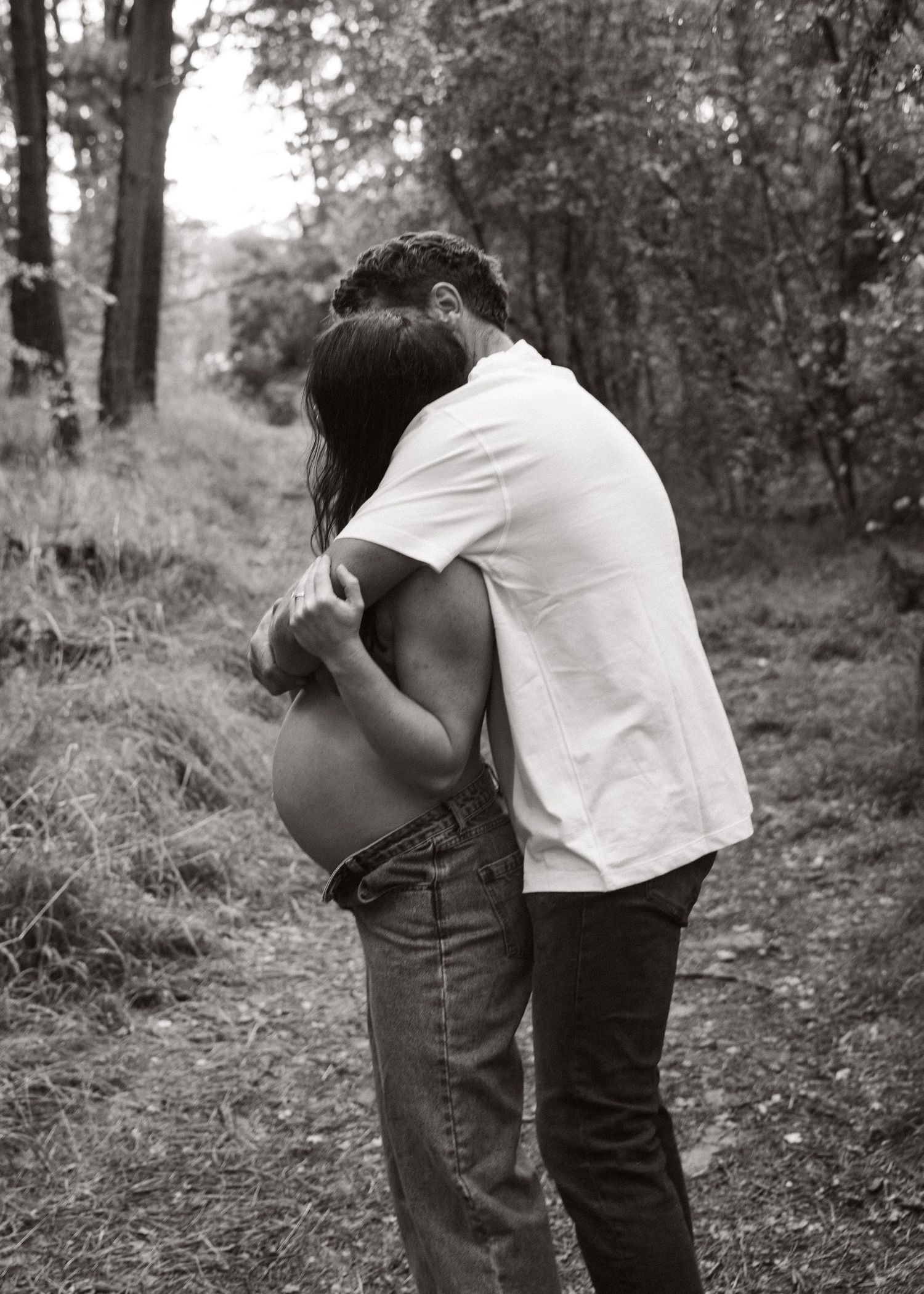 An Adelaide couple at a maternity photoshoot in the forest at golden hour.