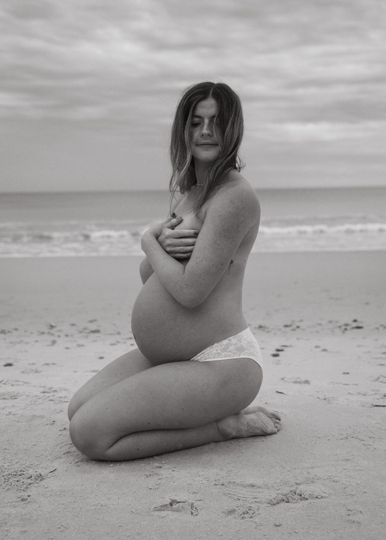 An Adelaide mother at a maternity photoshoot at the beach at golden hour.