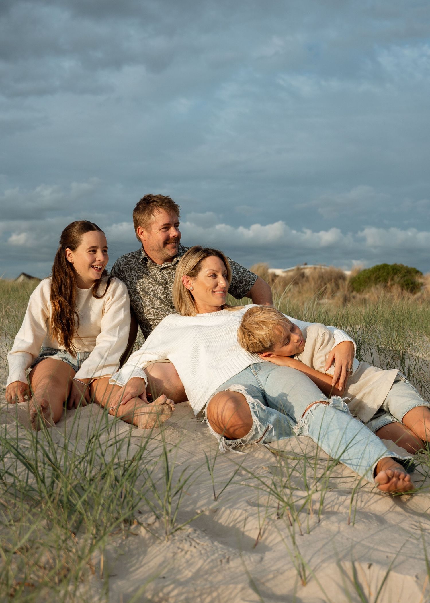 A family photography session at the beach at sunset with their 2 children.