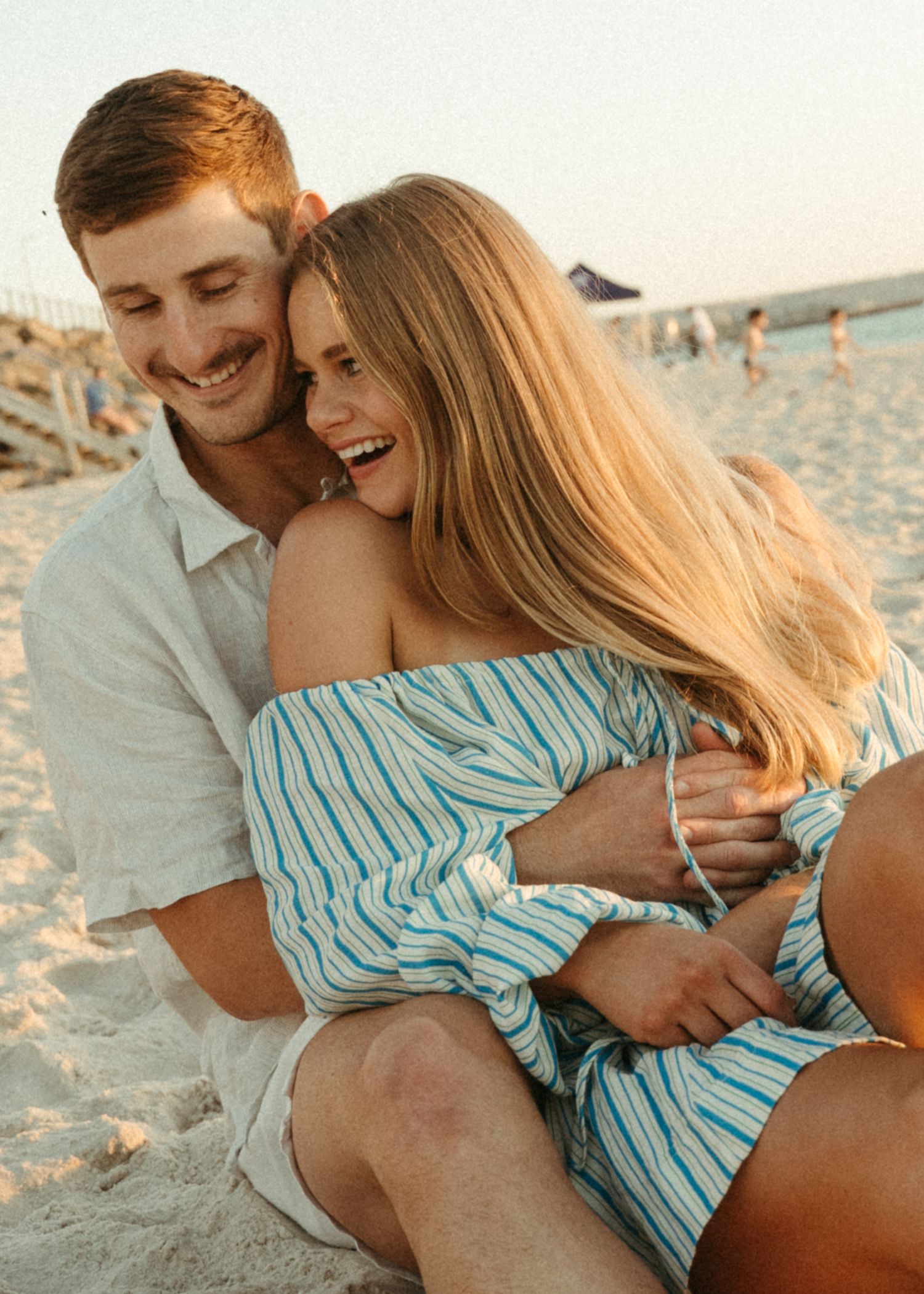 Couple and their dog at a couples photoshoot at an Adelaide beach at sunset, golden hour.