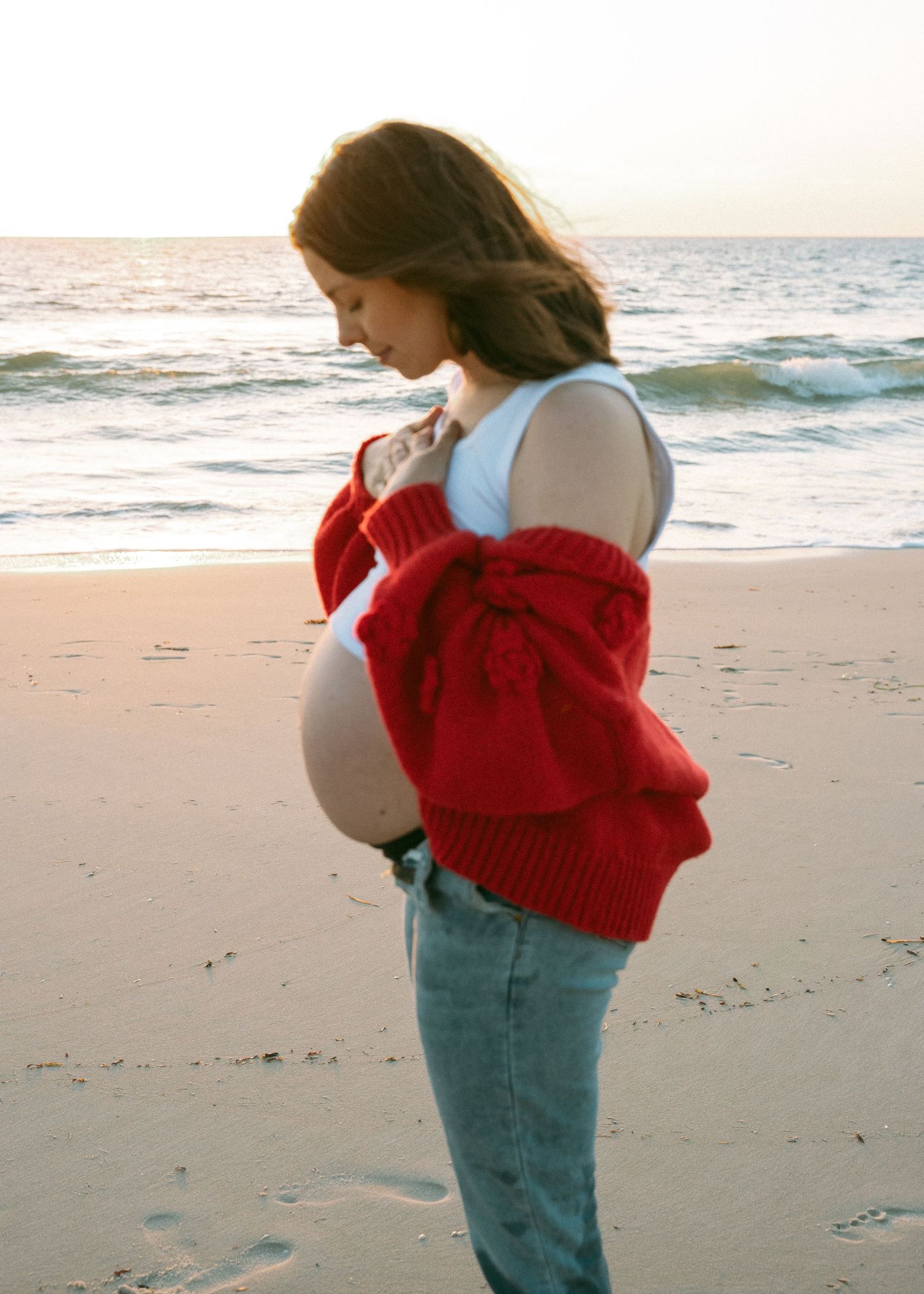 An Adelaide mother at a maternity photoshoot at the beach at golden hour.