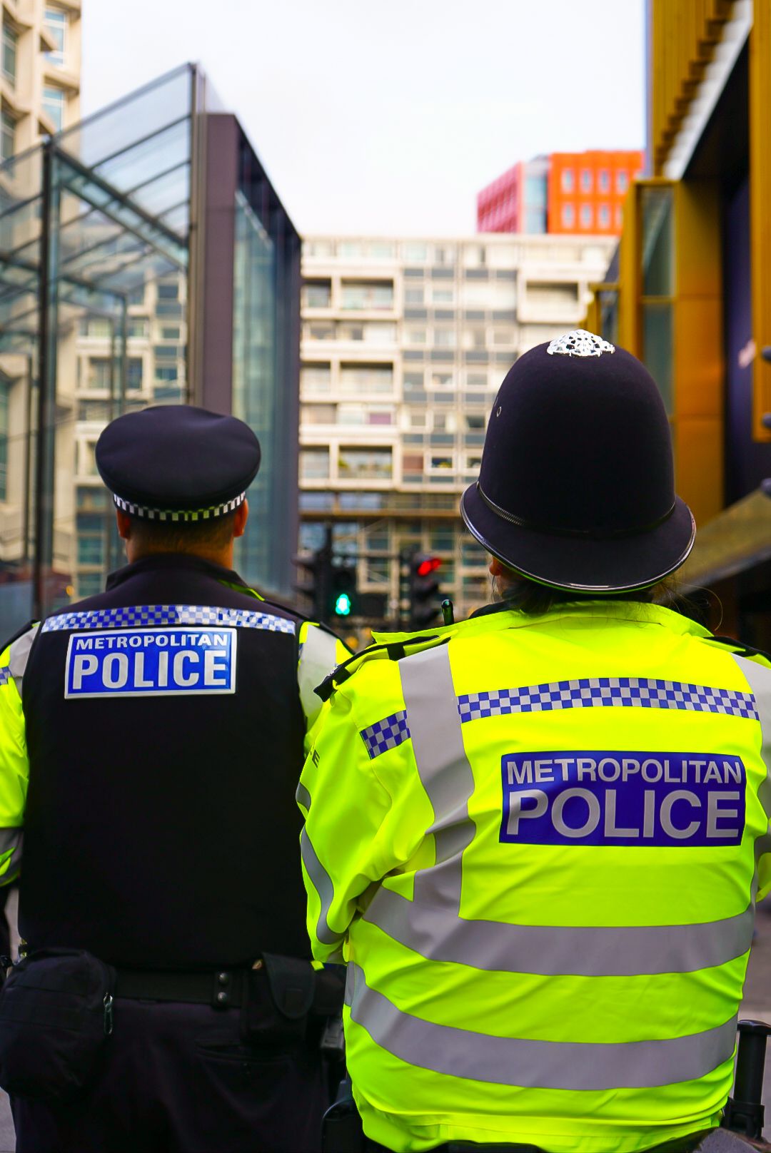 Two Metropolitan Police officers in high-visibility jackets on duty in London.
