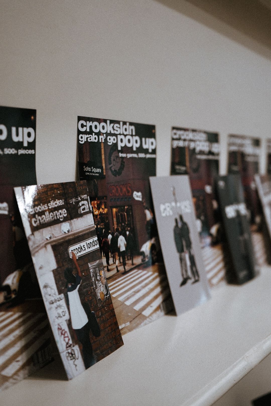 Crooks & Castles grab n go pop up event promotional posters displayed on a white wall.