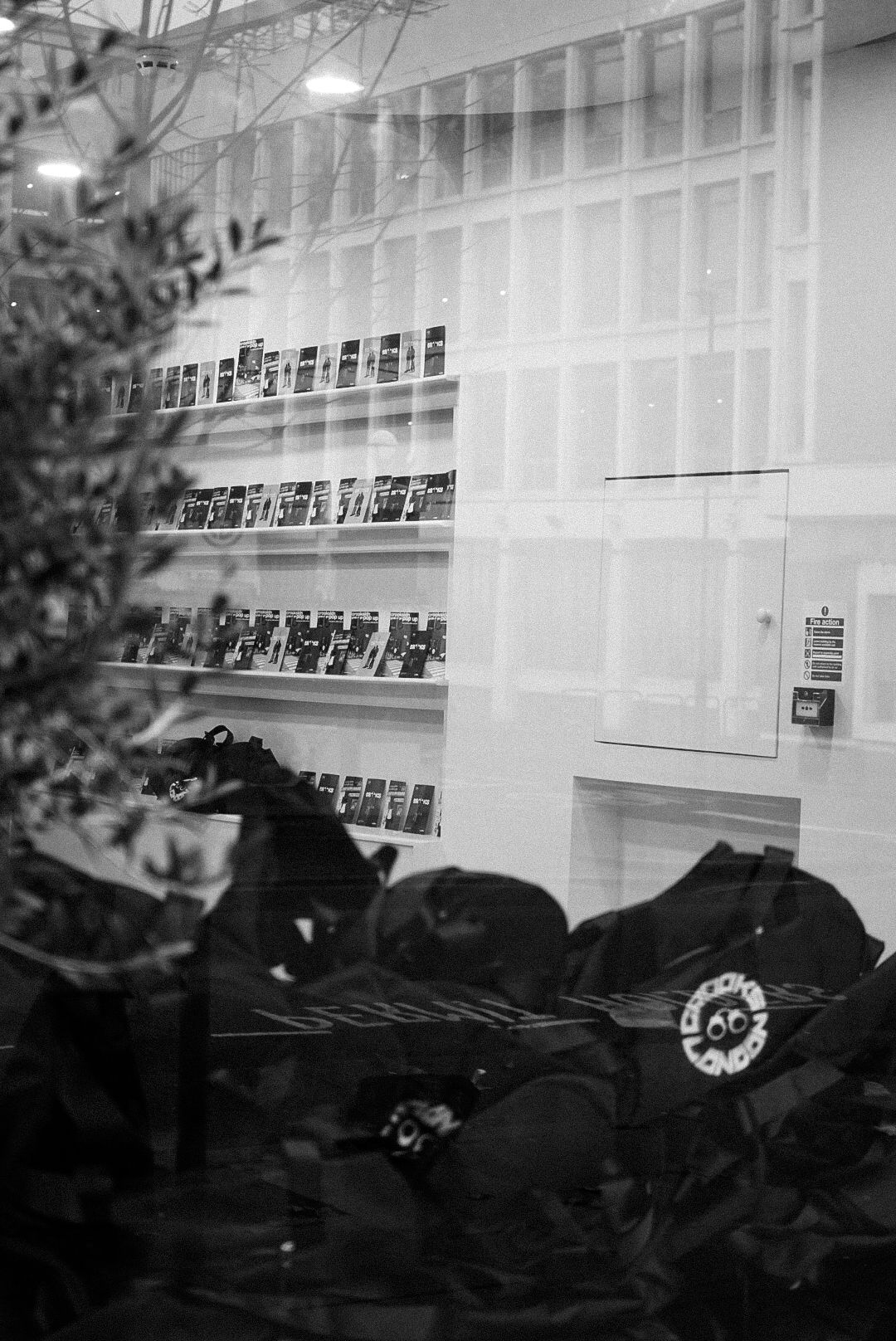 Black and white photo of merchandise displayed on shelves in a retail store window.